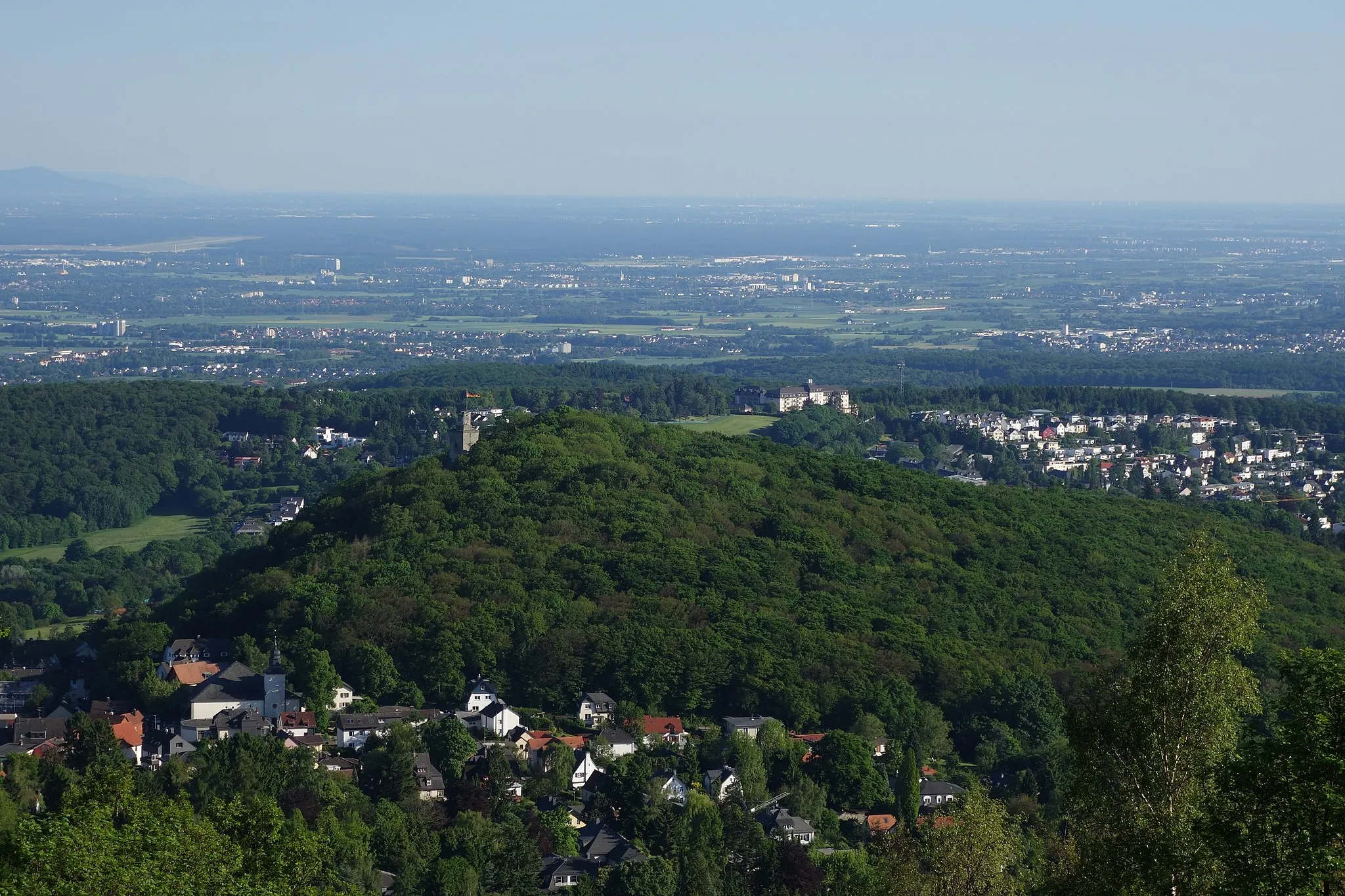 Photo showing: Blick vom Lipstempel (Altkönig) auf Burghain und Burgruine Falkenstein (Taunus). Hinten links am Horizont der Melibokus im Odenwald, davor die Startbahn West.