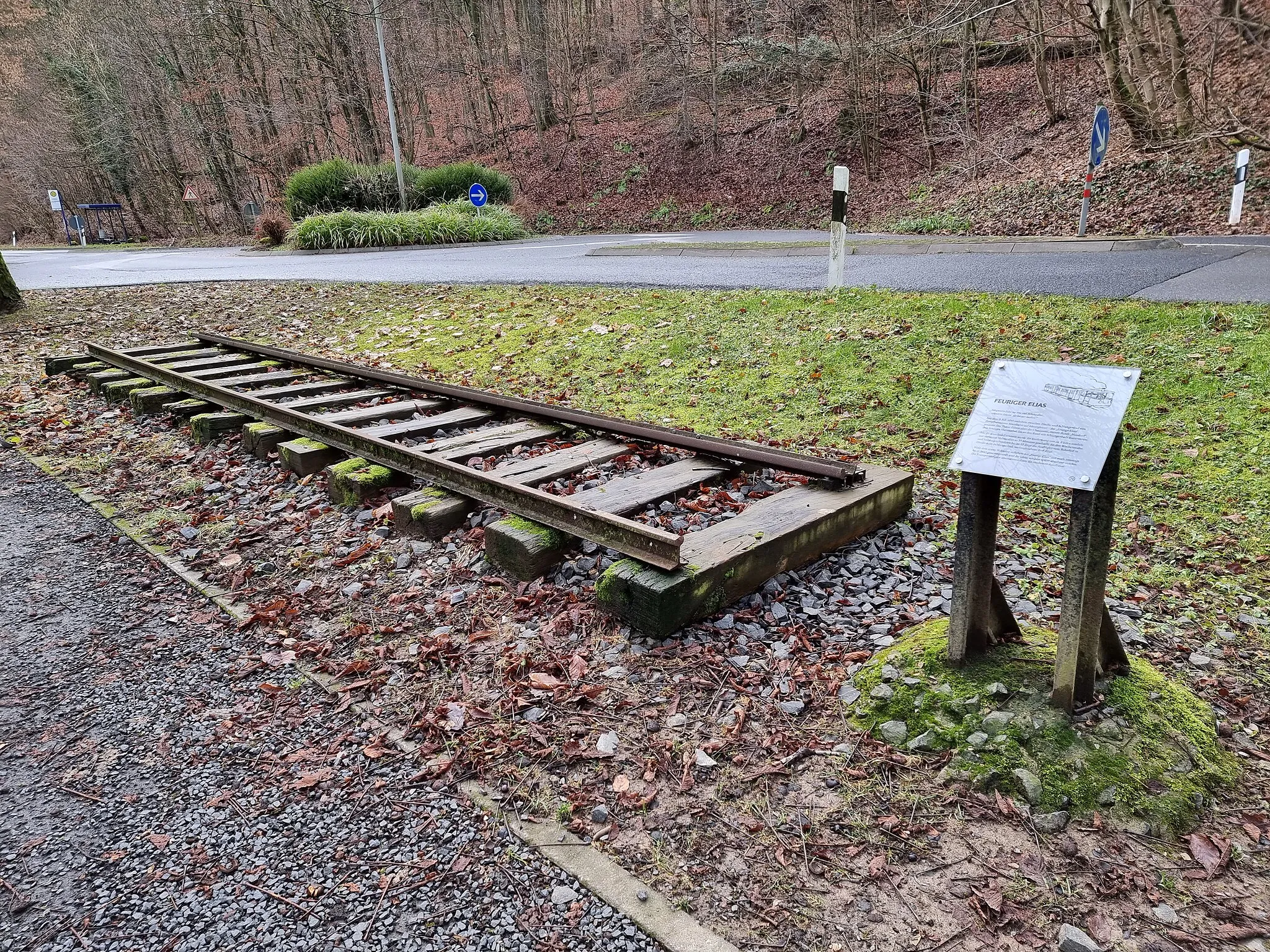 Photo showing: Gedenktafel mit Schienenresten in Erinnerung an die ehemalige Kleinbahn Eltville–Schlangenbad ("Feuriger Elias") am Ortseingang von Schlangenbad.