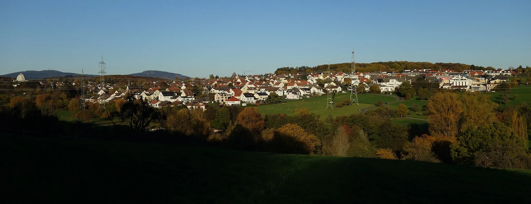 Photo showing: Hofheim-Langenhain as seen from the west; on the far left the Bahai temple, behind of it are the mountains "Kleiner Feldberg" and "Großer Feldberg" (with towers); half left is mountain "Altkönig". Half right in the middle is the road to Wallau