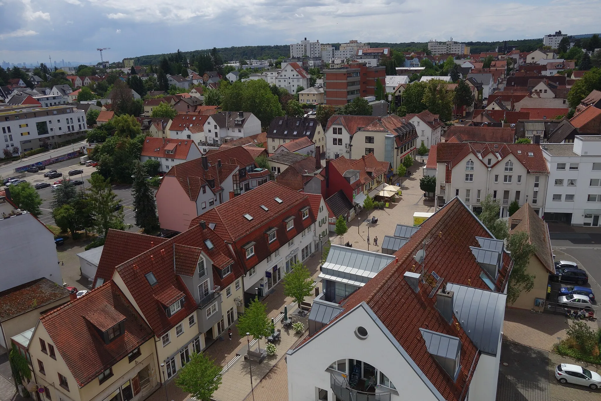 Photo showing: View over city and southern part of Friedrichsdorf as seen from roof of Salus Klinik. In the foreground Hugenottenstraße and Landgrafenplatz, the red brick-building in the middle is the town hall, Hardtwald forest at the horizon; on the left in the back Frankfurt's skyline