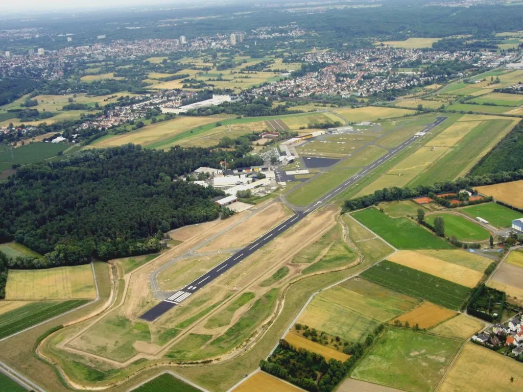 Photo showing: Luftaufnahme de:Flugplatz Frankfurt-Egelsbach; dahinter Egelsbach, im Vordergrund der wegen der verlängerten Bahnen des Flugplatzes künstlich umgeleitete Bachlauf des Hegbachs