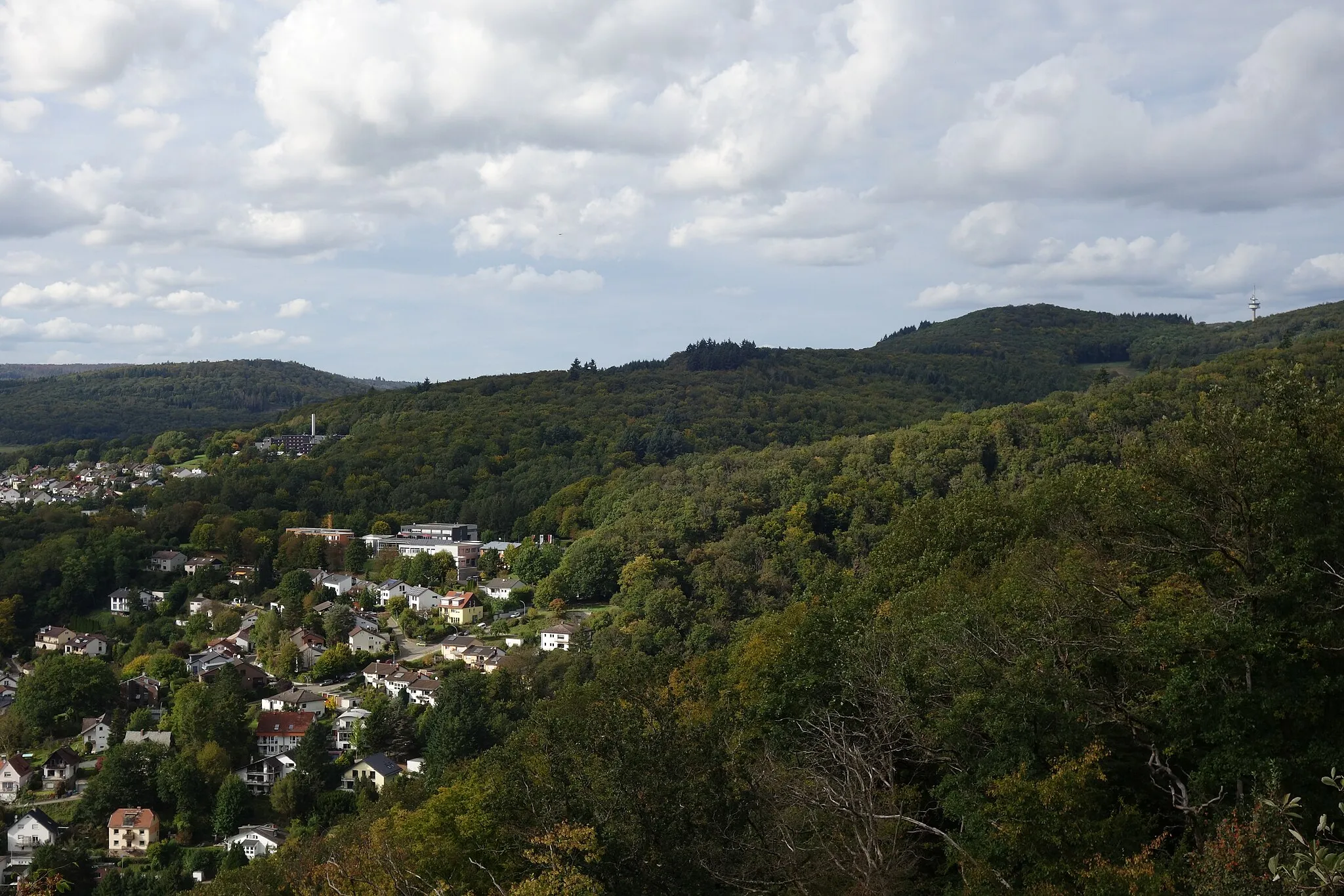 Photo showing: Westliche Rossert-Nebenkuppe Hainkopf (halbrechts) über Eppstein vom Kaisertempel gesehen, rechts davon der Atzelbergturm. Hinten links der 433,8 Meter hohe Küppel bzw. Hammersberg bei Ehlhalten, darunter die Sparkassenakademie Hessen-Thüringen in Eppstein. Dahinter am Horizont der Große Lindenkopf (499 Meter