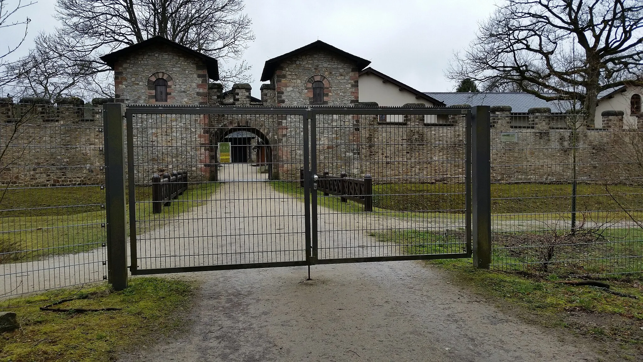 Photo showing: Mindestens seit 2009 wird die von Römern erbaute Mauer des Kastells Saalburg von einem weiteren Zaun geschützt.
Der früher frei nutzbare Weg um die Saalburg herum kann nun nur noch Eintrittsgeld betreten werden.

Ein freier Blick auf die Saalburg ist auch nicht mehr möglich.