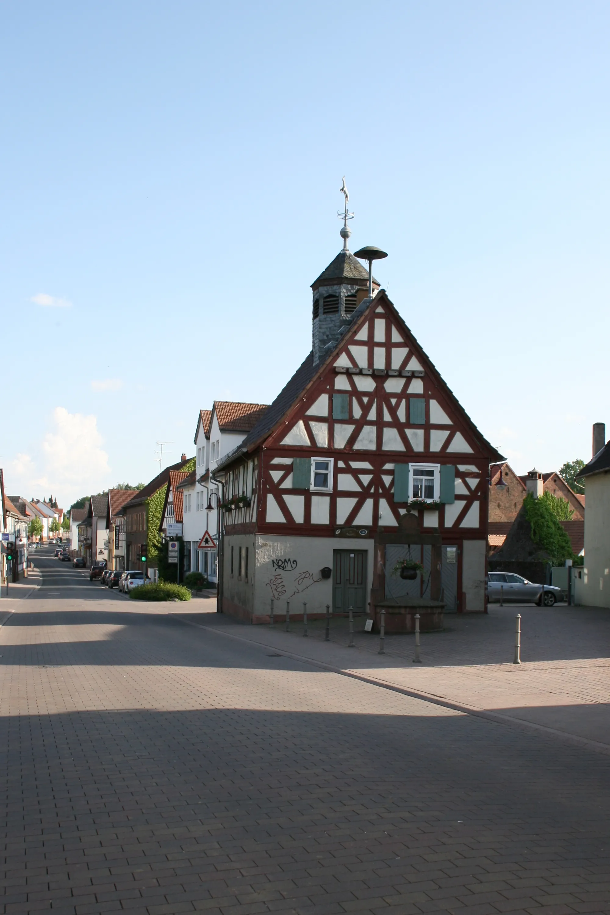 Photo showing: Hauptstraße (Hanauer Str.) mit Altem Rathaus (um 1700) in Bruchköbel-Roßdorf, davor der Rathausbrunnen (um 1713), rechts dahinter Backhaus (um 1773).