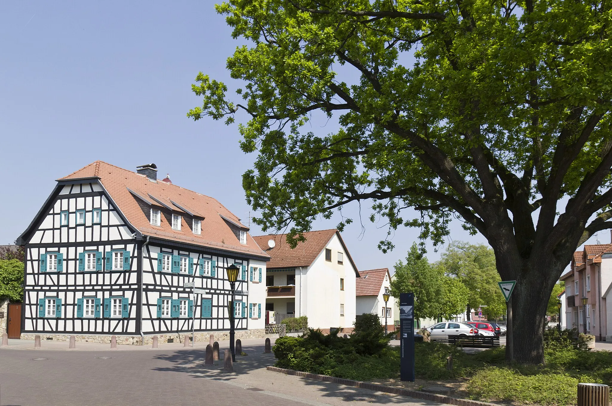 Photo showing: Rüsselsheim, Stadtteil Königstädten, Bismarckplatz. Seinen Namen erhielt der Platz im Jahre 1895, als die Eiche rechts im Bild zu Ehren des früheren Reichskanzlers Otto von Bismarck gepflanzt wurde.