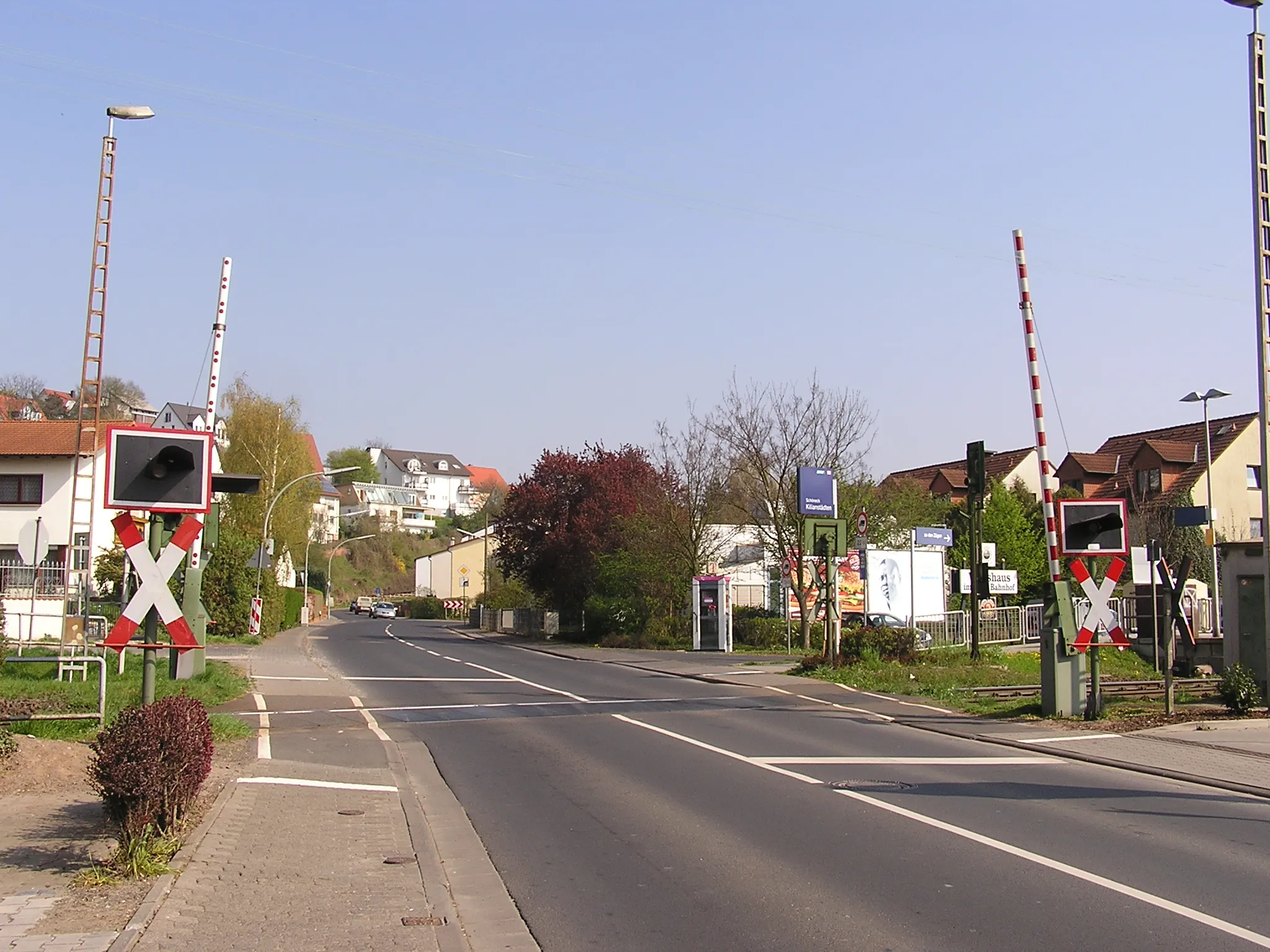 Photo showing: This level crossing with gates an blinking lights at the Niddertalbahn is located in Schöneck-Kilianstädten.