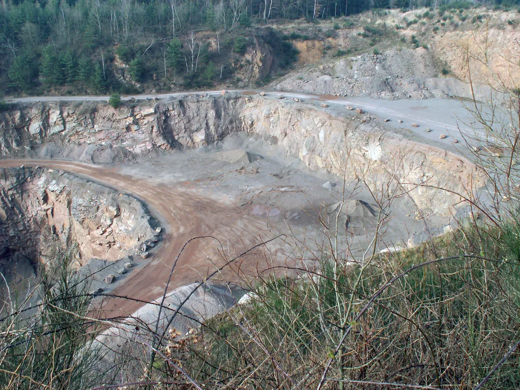 Photo showing: Syenite quarry at Teufelsplatzweg (“devil's place route”) between the villages Messel, Rossdorf and Dieburg, southern Hesse, Germany. The syenite quarried here is part of the crystalline basement (Mid-German Crystalline Rise of the Variscides), on which further to the north the Eocene sediments of the Grube Messel (Messel Formation) came to rest and which is a northerly extension of the crystalline part of the Odenwald Mts.