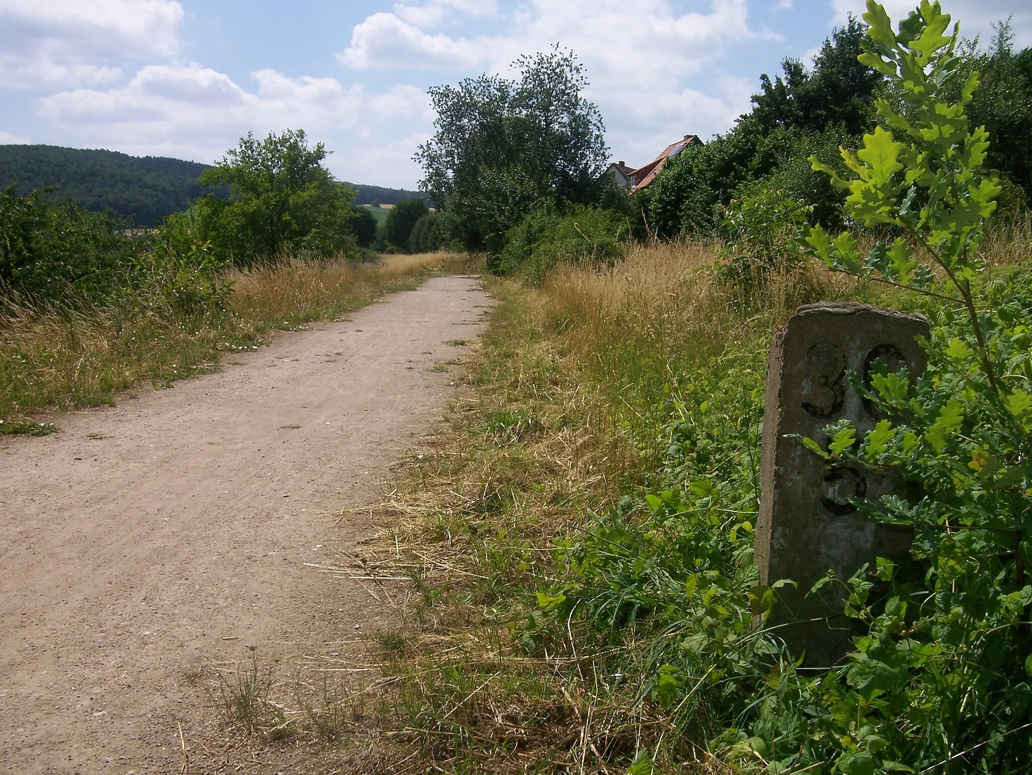 Photo showing: Heutiger Radfahrweg auf der ehemaligen Bahntrasse bei Reher - Mit Kilometerstein am Wegrand