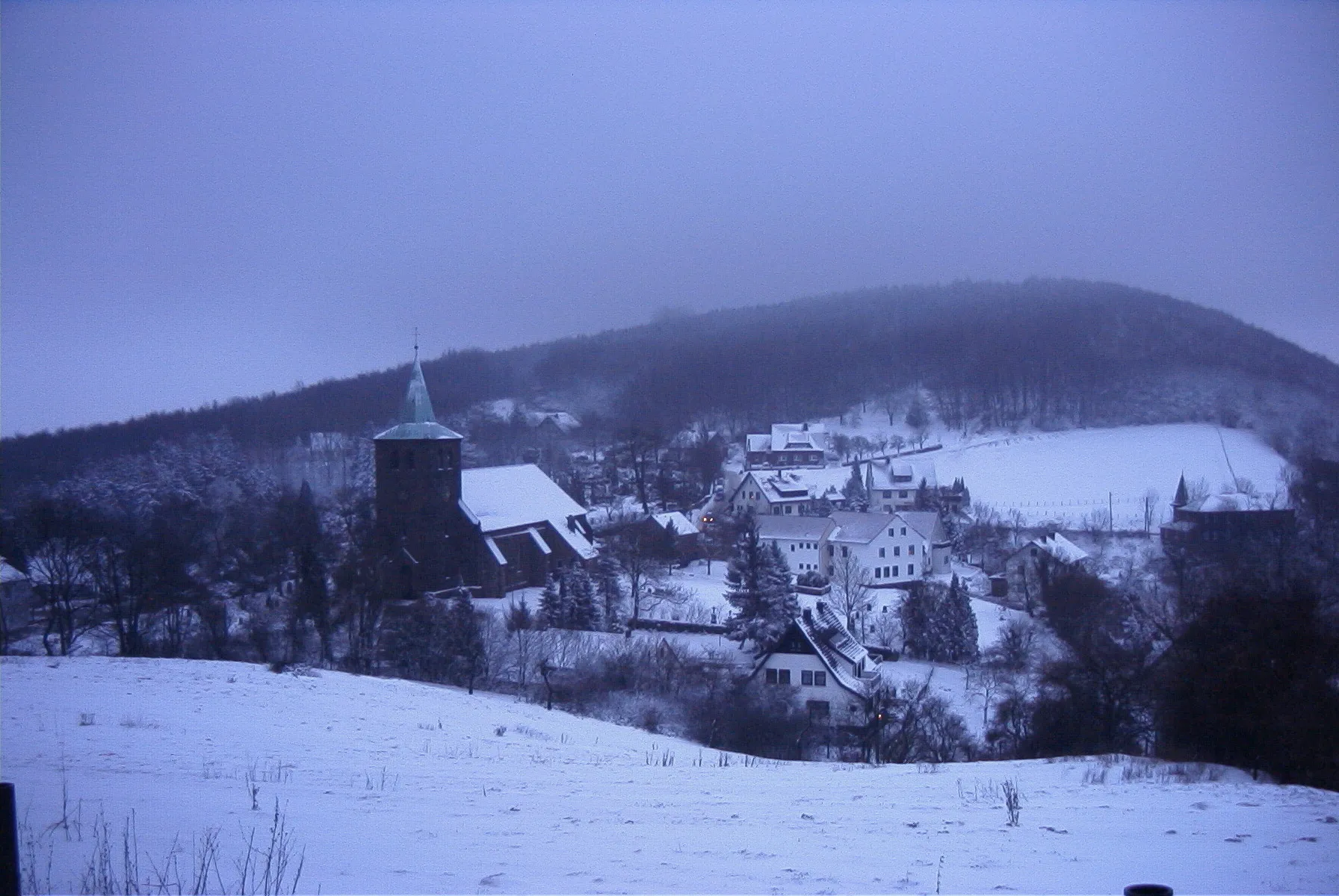 Photo showing: Blick vom Osthang des Berkirchener Kopfes auf das Dorf Bergkirchen, Wiehengebirge im Winter 2000