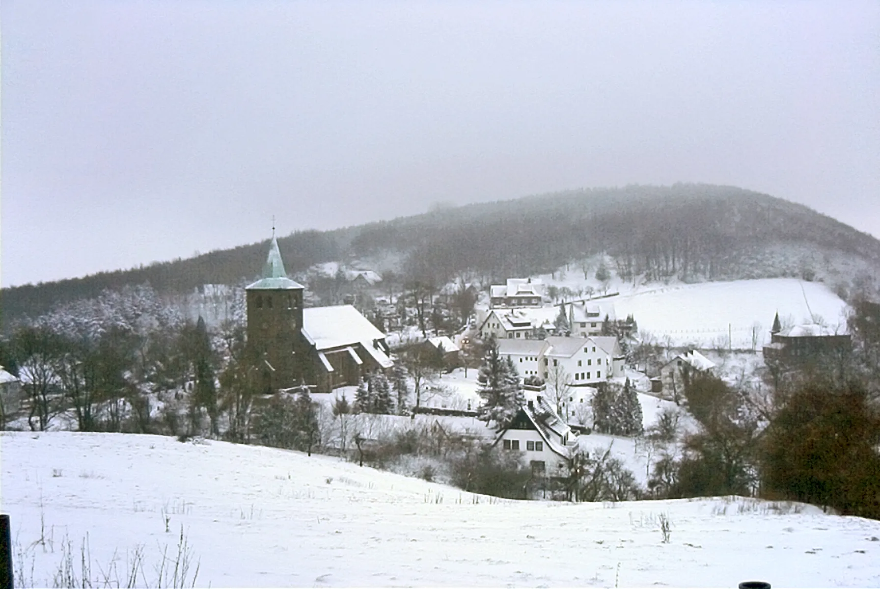 Photo showing: Blick vom Osthang des Berkirchener Kopfes auf das Dorf Bergkirchen, Wiehengebirge im Winter 2000