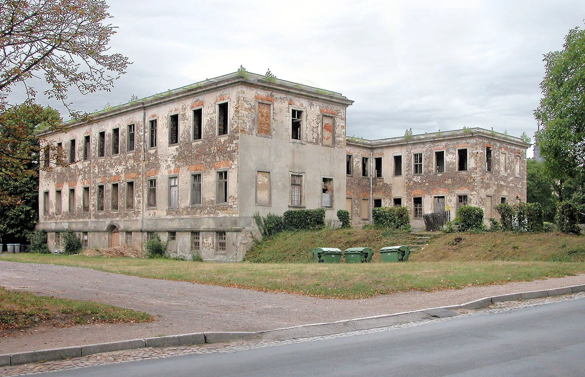 Photo showing: 08.08.2006  04774 Dahlen, Schloßstraße: Barockschloß (GMP: 51.367496,12.995934). Das Dahlener Schloß gehörte einstmals zu den prächtigsten Adelssitzen in Sachsen. Erbaut wurde es durch den Grafen Heinrich von Bünau (1697-1762) der das Rittergut Dahlen durch Heirat 1721 in seinen Besitz gebracht hatte. Das 1744 bis 1751 erbaute Schloß besteht aus einem Mitteltrakt und zwei Seitenflügeln, die sowohl auf der Hof- als auch auf der Gartenseite hervortreten. Dadurch entsteht im Grundriss die Form eines H. Die Mitte wird durch einen Eingangsrisalit betont. Auf dem geschwungenen Giebelfeld sind  Löwen dargestellt, die das Wappen des Grafen tragen. Der Baumeister des Schlosses ist nicht bekannt, doch vieles spricht dafür, dass der Oberlandbaumeister Johann Christoph Knöffel (1686-1752) am Entwurf beteiligt war. Zustand nach dem Brand vom 20. März 1973. Ansicht Straßenseite.                                                                                                                                                                                                                     [DSCN10954.TIF]20060808160DR.JPG/Blobelt