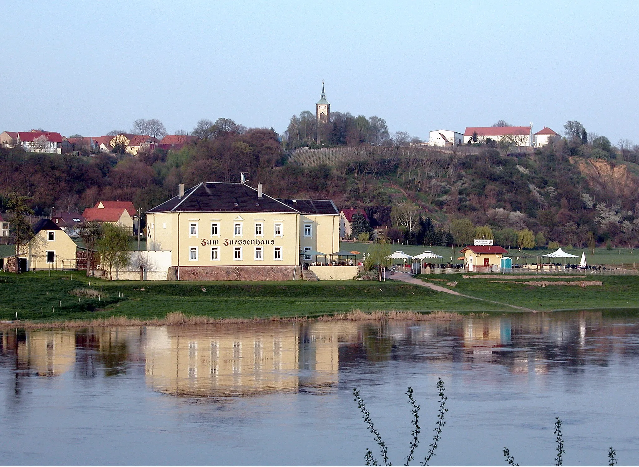 Photo showing: 10.04.2009  01665  Zadel (Diera-Zehren): Blick von Zehren über die Elbe nach Zadel. Im Vorgergrund das "Zum Zuessenhaus" (GMP: 51.195006,13.419016), Elbstraße 10. Auf dem Hochufer der Ort Zadel mit der St.-Andreas-Kirche Zadel (GMP: 51.196776,13.428570) Rechts davon das ehemalige Kammergut. Links der Kirche das Gehöft vom Weingut Schloß Proschwitz, Dorfanger 19, Zadel (GMP: 51.197541,13.427995).                                                                                                                           [DSCN36274]20090410835DR(c)Blobelt