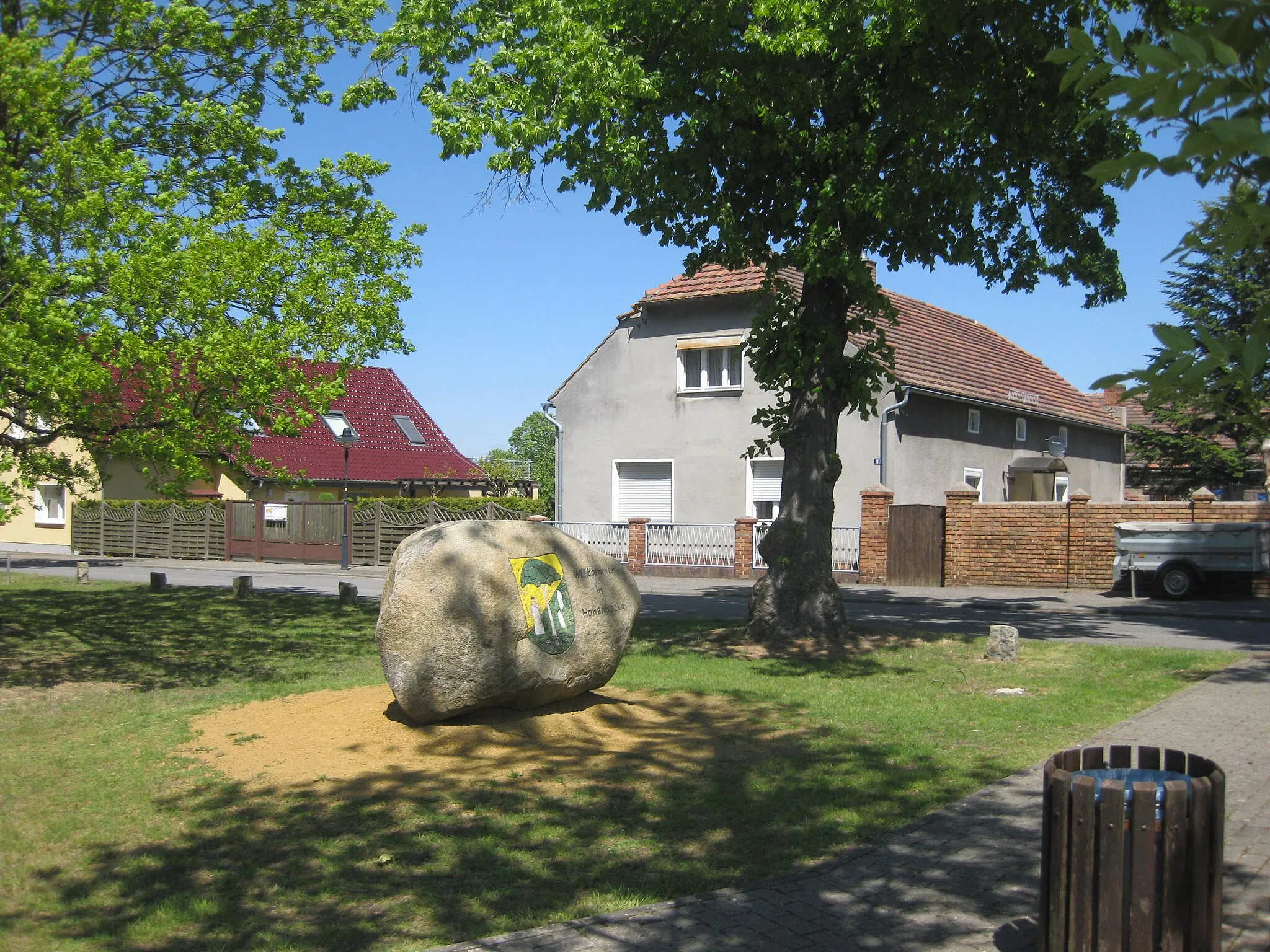 Photo showing: Hohenbocka, Dorfaue, Willkommen-Stein gegenüber Hausnr. 10, Südansicht, Spätfrühling; im Blick Hausnr. 11 und 13 (links)