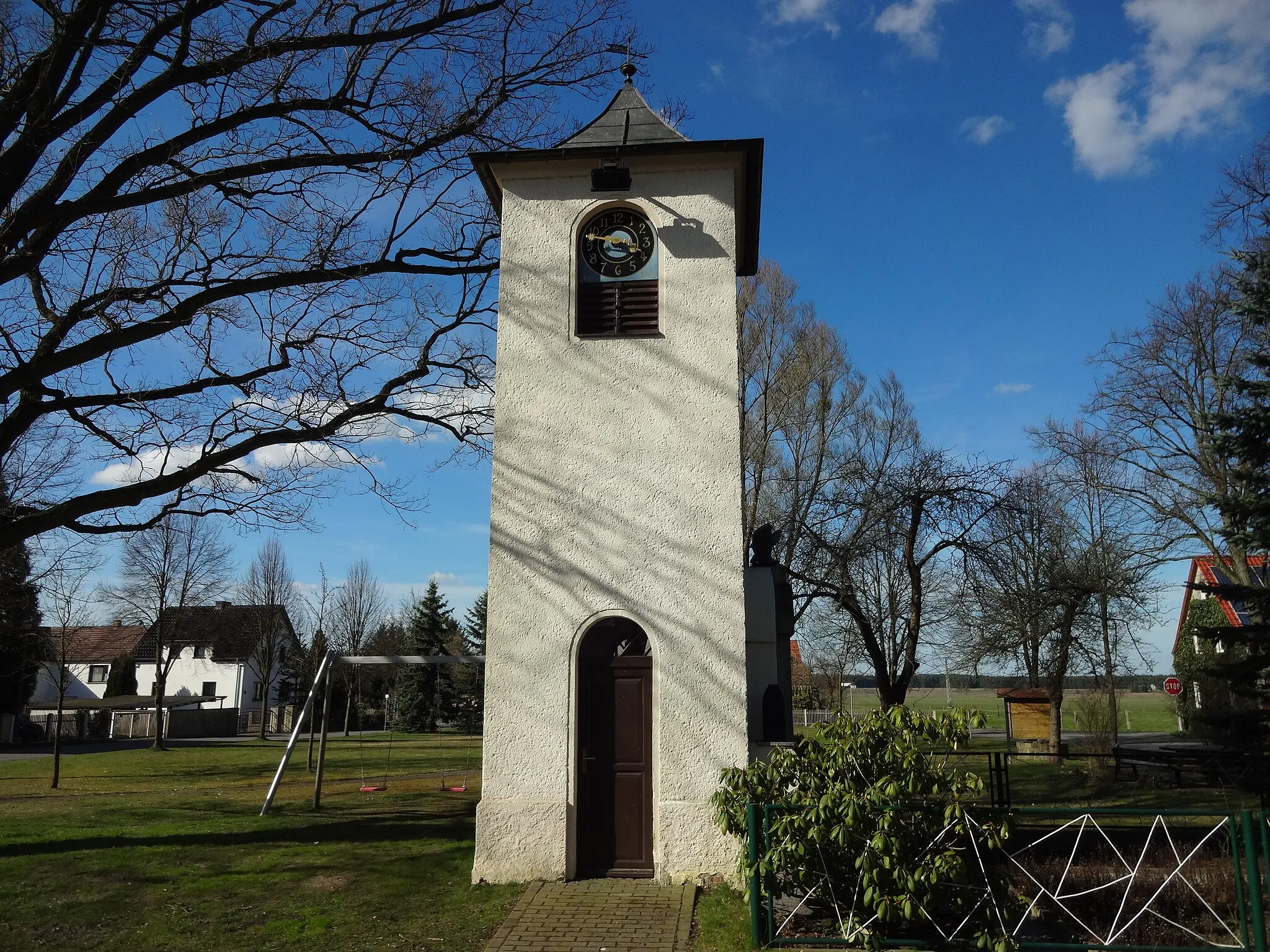 Photo showing: Glockenturm auf dem Dorfplatz in Sella einem Ortsteil von Grünewald Am Glockenturm befindet sich ein Kriegerdenkmal für die Gefallenen des Ersten Weltkriegs