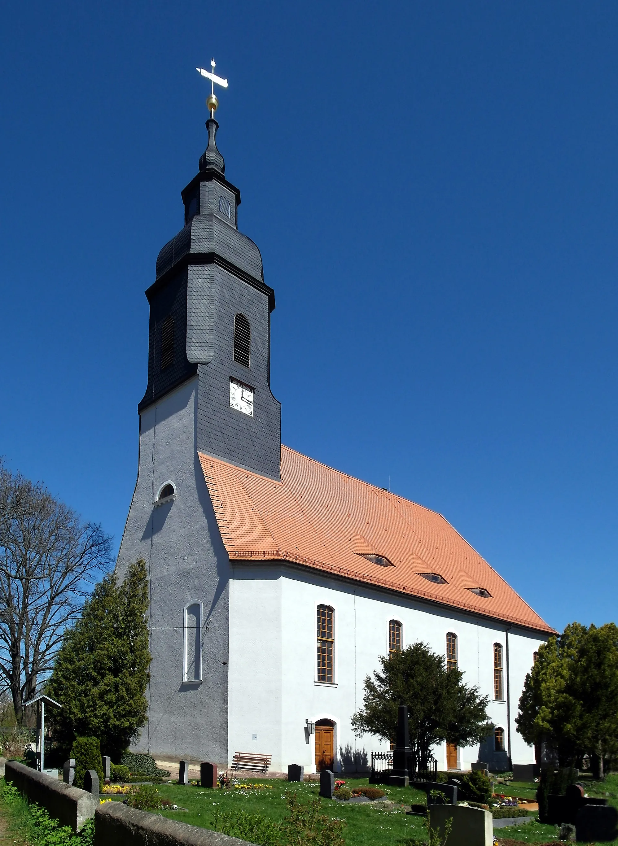 Photo showing: 20.04.2015    01665   Krögis (Käbschütztal), Kirchgasse: Dorfkirche (GMP: 51.120580,13.379604). 1733 wurde die jetzige Saalkirche als vollständiger Neubau geweiht. Im Jahr darauf wurde auch der neue Turm vollendet, der über der Mitte der Kirche errichtet wurde. Nachdem schon 1773, 1743 und 1768 und 1794 Blitze Kirche und Turm arg verwüstet hatten, musste dieser abgetragen werden. Erst 40 Jahre später, als ein großes Feuer im Dorf und auch an der Kirche viel Schaden angerichtet hatte, wurde 1835 der heutige Turm an der Westseite der Kirche gebaut. 1850 wurde die Kirche im Innern vollständig verändert und ein klassizistischer Kanzelaltar eingebaut. Der vorhergehende Altar von 1660 ist nun ist der Wolfgangskapelle in Meißen zu besichtigen. Ende des 19. Jahrhunderts musste die alte Orgel ersetzt werden. Seitdem erklingt in der Kirche zum Gottesdienst ein Instrument der Firma Eule aus Bautzen.                                          [SAM9902.JPG]20150420405DR.JPG(c)Blobelt