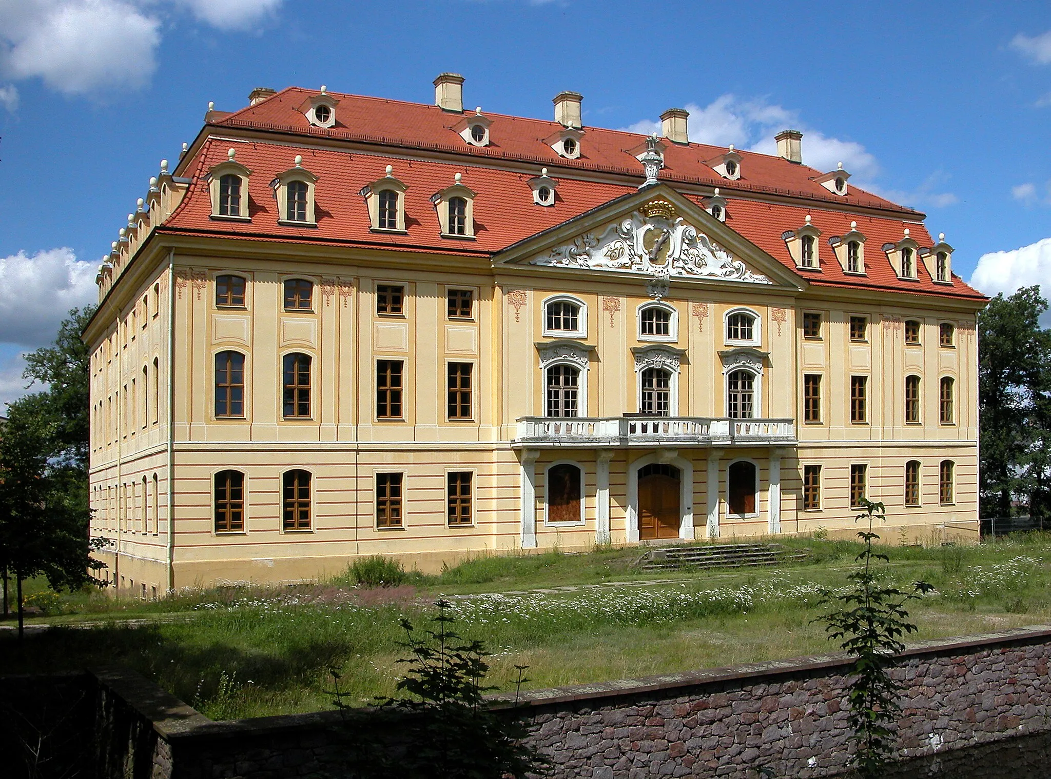 Photo showing: 09.07.2012   01454  Wachau, Am Schloß 1 (GMP: 51.158825,13.903120): Wasserschloß,  errichtet 1730-1754 auf älterer Grundlage für Johann Georg von Schönfeld. Ab 1800 im Besitz der Herren von Oppel. In der DDR-Zeit sind im Schloß Wohnungen, eine Arztstation, das Standesamt, die Bücherei, der Schulhort und zwei Verkaufsstellen. 1991-1998 werden Dach- und Fassaden saniert, die Fenster erneuert, der Schloßteich entschlammt und die Ufermauern neu errichtet. Ansicht Parkseite. [DSCNn4310.TIF]20120709215DR.JPG(c)Blobelt