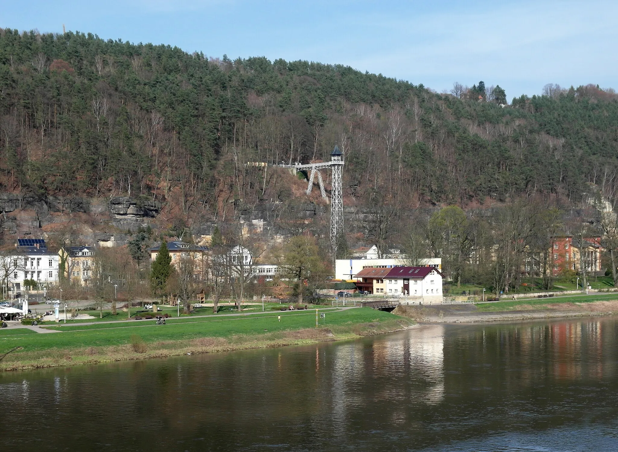 Photo showing: 05.04.2016   01814   Bad Schandau:  Blick von Süden über die Elbe zum  Ostrauer Aufzug (GMP: 50.916712,14.161279). Der historische Personenaufzug ist eine 50 Meter hohe, freistehende Eisenkonstruktion, die zum höher gelegenen Ortsteil Ostrau führt.  Der Hotelier Rudolf Sendig ließ diesen elektrisch betriebenen  Aufzug 1904 durch die Firmen Kelle & Hildebrandt  (Eisenkonstruktion)  und Kühnscherf & Söhne (Aufzug) errichten. Am Ostersonntag 1905 wurde der Aufzug offiziell eingeweiht. Rechts oben ist klein ein Haus der Sendig-Holzhaussiedlung zu erkennen. Links unten neben dem Aufzug die weiße 1885 erbaute "Russische Villa" die R. Sendig der derzeitigen Kaiserin von Rußland für erholungsbedürftige Offiziere zur Verfügung stellte. Seit 1927 als katholische Kirche genutzt.                 [SAM4313.JPG]20160405710DR.JPG(c)Blobelt