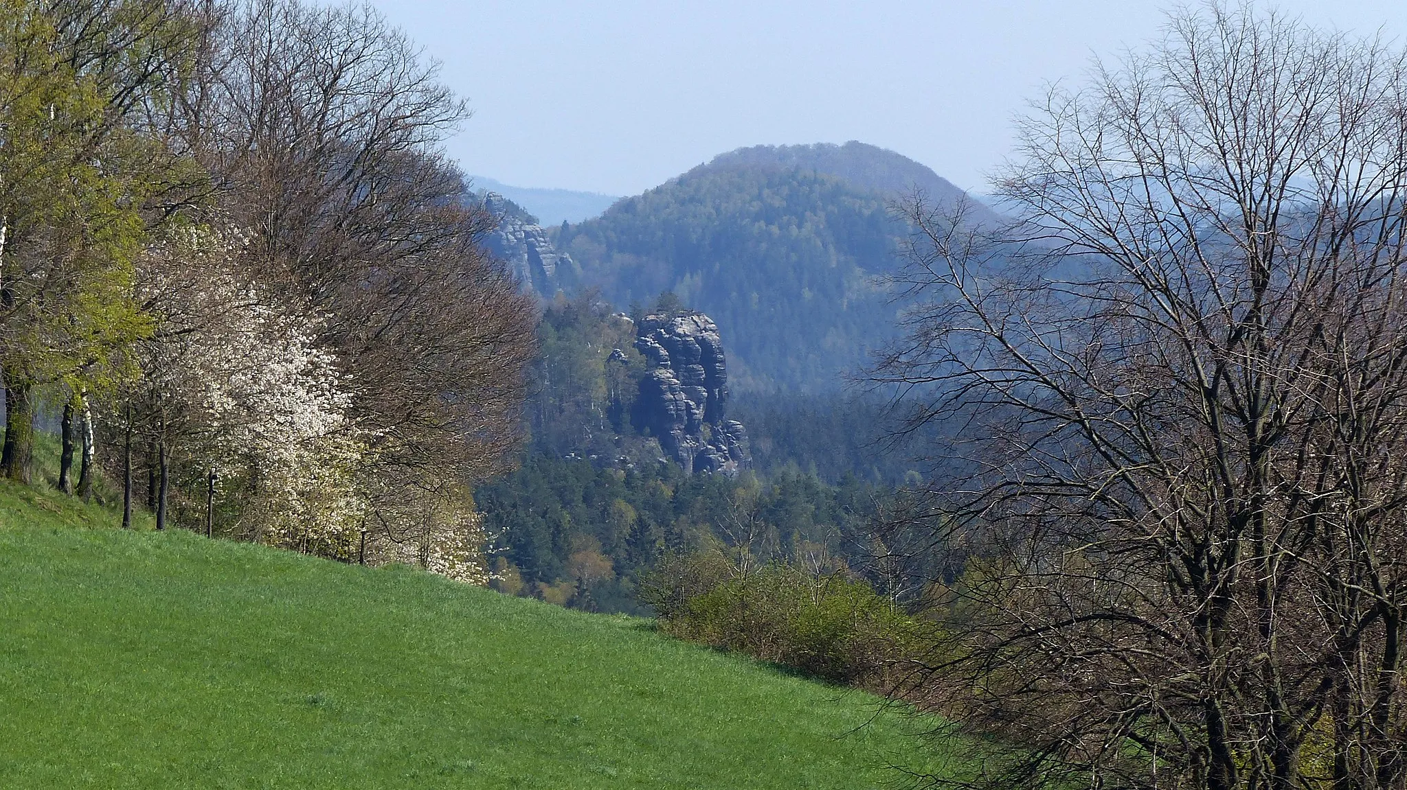 Photo showing: Blick auf den Raumberg (459 m) in der Sächsischen Schweiz, von Norden (Mittelndorf) aus; davor: Hochhübel (406 m); links davor: Neuer Wildenstein (mit Kuhstall) und dahinter Lorenzsteine