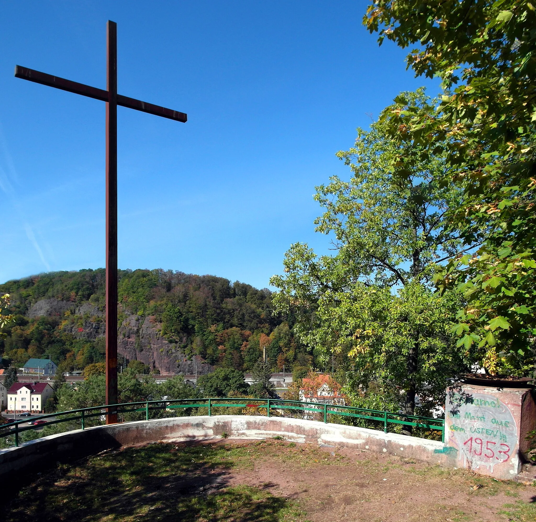 Photo showing: 05.10.2018   01734  Rabenau: Quellenberg-Denkmal, Großkreuz (GMP: 50.981842,13.634261) am Quellenberg, flankiert von zwei eisernen Feuerschalen. Erbaut 1934 zum Gedenken an die Toten des I. Weltkrieges. Obwohl auf Rabenauer Flur, liegt es direkt oberhalb der Kirchstraße von Freital-Hainsberg. Im Hintergrund der Backofenfelsen. Blick nach Westen.                                                                           [SAM8091-8092.JPG]20181005210MDR.JPG(c)Blobelt