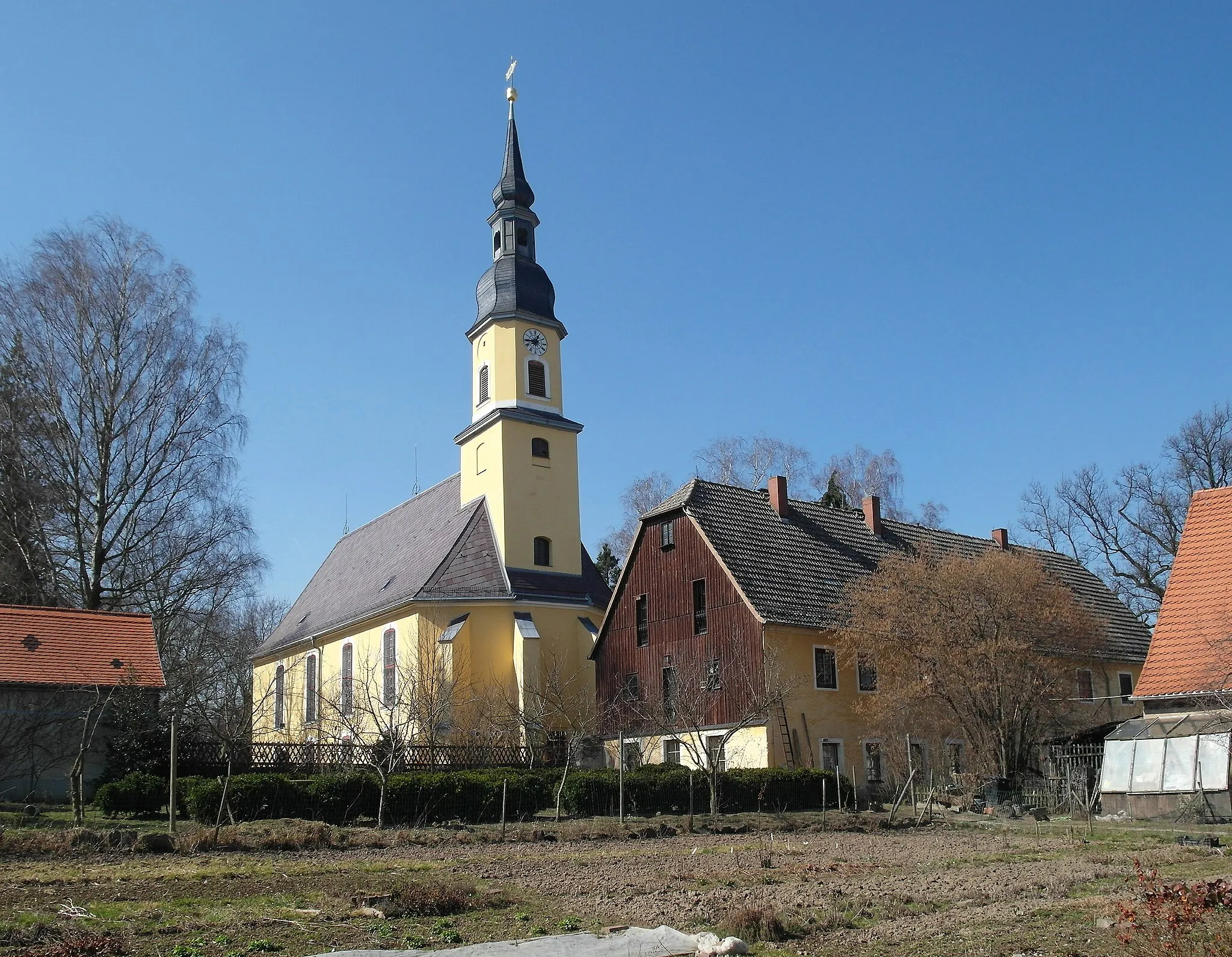 Photo showing: 19.03.2015    01723    Blankenstein (Wilsdruff), Kirchweg 2: Dorfkirche (GMP: 51.037731,13.429767) und Pfarrhaus. Blankenstein wurde als Ort 1283 erstmals erwähnt und ist als Waldhufendorf angelegt. 1435 kam Blankenstein in den Besitz der Herren von Schönberg. In dieser Zeit, um 1480, entstand die Kirche. Nach einem Umbau im Jahr 1738 erhielt sie ihre heutige Gestalt. Bei ihrem Bau sollen Steine des zusammenfallenden Schlosses verwendet worden sein. Direkt im Anschluss an Kirche und Gottesacker befindet sich das Pfarrgut (GMP: 51.037869,13.430073).                                                      [SAM9064.JPG]20150319410DR.JPG(c)Blobelt