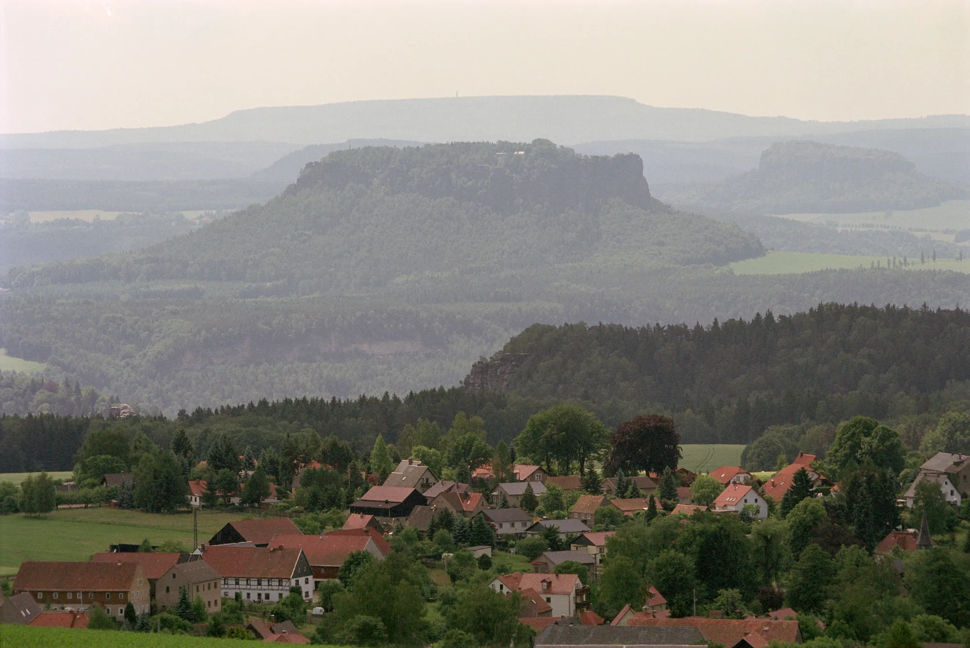 Photo showing: Děčínský Sněžník (de: Hoher Schneeberg, also Tetschner Schneeberg (snow-mountain)), mountain in Czech Republic

view from Hohburkersdorfer Rundblick in Germany
in the foreground mountain Lilienstein, right Pfaffenstein and in the background the Děčínský Sněžník
self-taken picture, taken in summer 2003