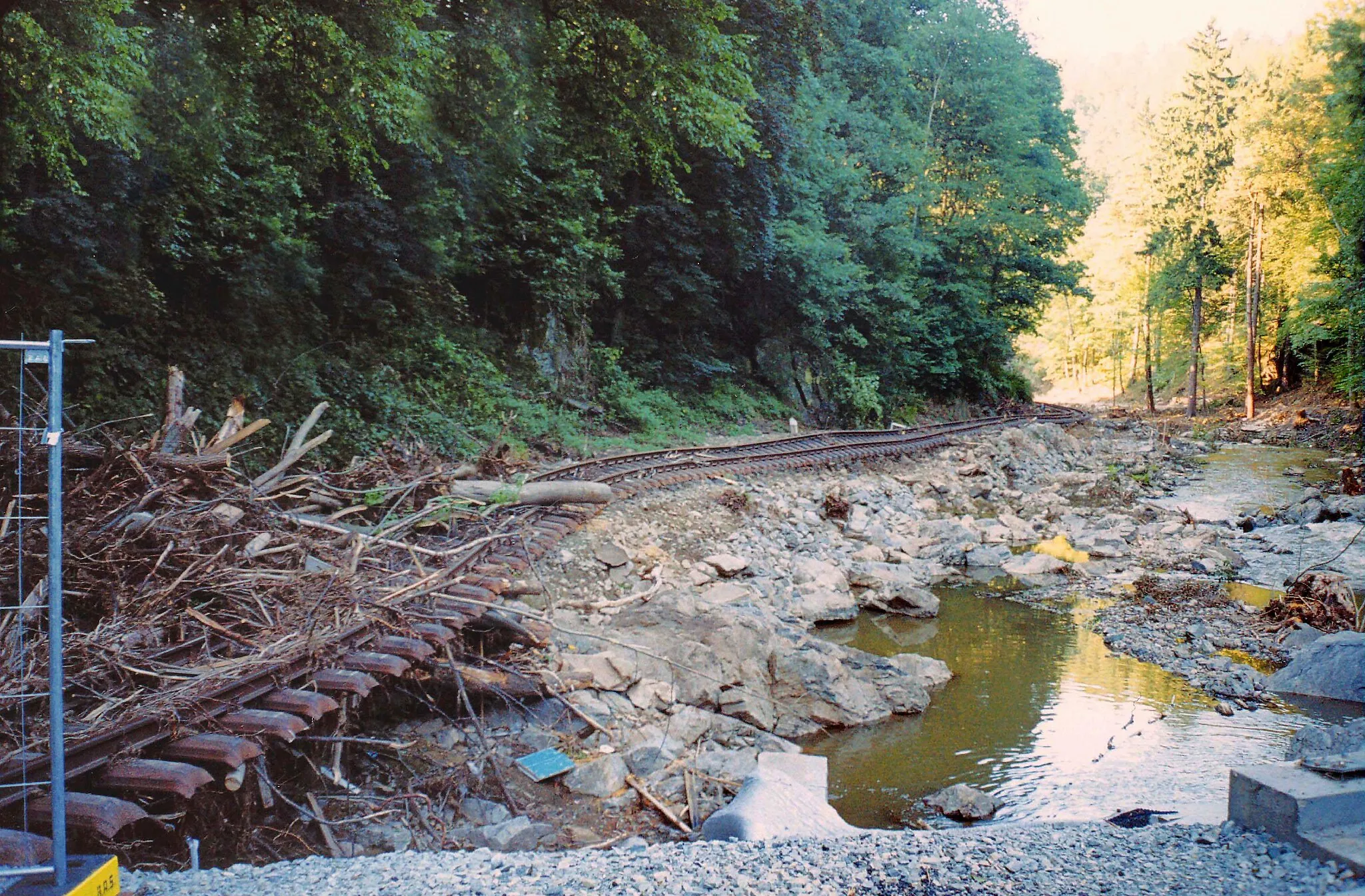 Photo showing: 08.09.2002    01734  Spechtritz (Rabenau): 200 m unterhalb vom Haltepunkt Spechtritz (GMP: 50.952603,13.638735) der Weißeritztalbahn. Am 30.10.1882 wurde die Schmalspurbahn Haisberg-Kipsdorf eröffnet. Schon 1897 war sie durch Hochwasser zerstört worden. Hier die erneuten Schäden durch das Hochwasser vom 13. August 2002. Sicht von der Straßenbrücke flußabwärts.                                                                                                                                                                                  [F20020818A20.JPG]20020908250AR.JPG(c)Blobelt