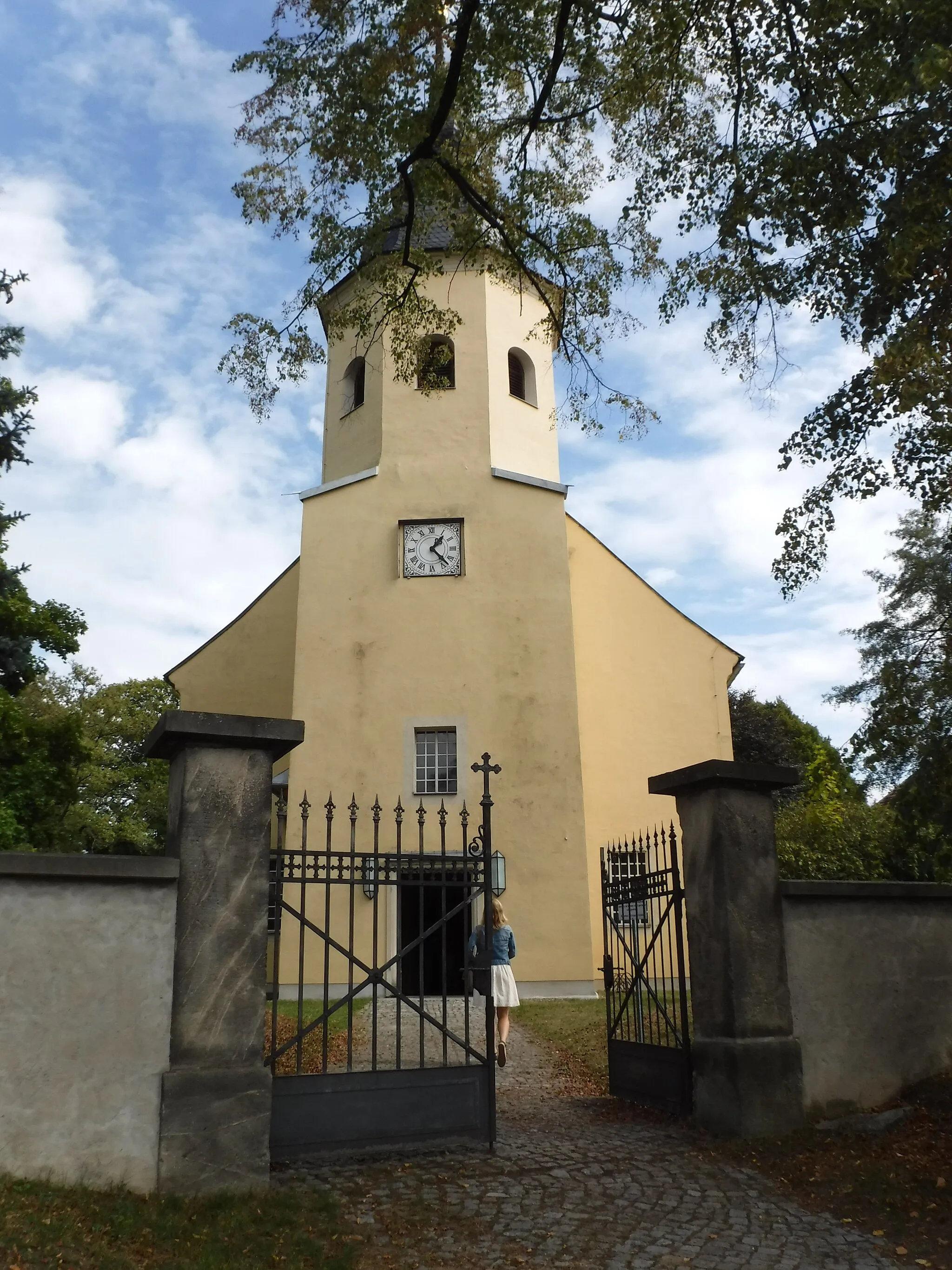 Photo showing: Evangelische Pfarrkirche Wachau (Sachsen)
Neubau des Kirchengebäudes anstelle des 1823 abgerissenen alten Baues, Einweihung des neuen Kirchenschiffes am 7. Dezember 1824 durch Johann August Leberecht Hoffmann; der Turm ist 1830 umfangreich saniert worden; 18. Jahrhundert (Grabmale)	Baugeschichtlich und ortsgeschichtlich von Bedeutung.
Große Saalkirche, 1820–23 neu errichtet unter Verwendung des Turmes von 1689. Putzbau mit gerade geschlossenem Chor, die Ecken angeschnitten, einheitliche Stichbogenfenster. Mächtiger Westturm auf quadratischem Grundriss, im Obergeschoss achteckig mit geschweifter Haube und Helm. Im Innern flachgedeckt, zweigeschossige Emporen an drei Seiten, an den Brüstungsfeldern bäuerliche Malereien mit Szenen aus dem Alten und Neuen Testament (18. Jahrhundert), vermutlich aus dem Erzgebirge. In den Chor ragen zwei Patronatslogen, an der Ostwand Wandmalerei mit Erzengeln mit Gesetzestafeln und Abendmahlskelch von Erhard Ludewig Winterstein aus Leipzig, um 1900. Schlichter klassizistischer Kanzelaltar aus Stuck und Holz, um 1820, Sandsteintaufe, um 1820, Porzellan-Kruzifix, gute Meißener Arbeit, 18. Jahrhundert.

Denkmal-ID 09284521