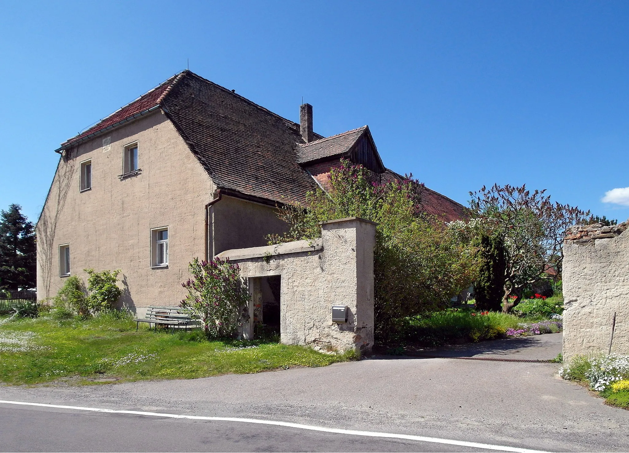 Photo showing: 09.05.2016   02994   Bulleritz (Gemeinde Schwepnitz): 	Ehem. Vorwerk Bulleritz, Hauptstr. 4. Wohntrakt im SW an der Straße. Caspar Burggraf von Dohna wurde 1565 mit dem Dorf Bulleritz belehnt. 1817 erwarben die Grafen zu Stolberg-Stolberg auf Brauna das Vorwerk, welches zum Ritterguts erhoben wurde. Der Wohntrakt ist zur Straße gerichtet. Er wurde 1821 von der Herrin auf Brauna, Sophie Charlotte Eleonore Gräfin zu Stolberg-Stolberg, erneuert, was eine Tafel am Giebel mit der Inschrift "K. E. Gr. z. St. geb. Gr. v. R. 1821" bezeugt. 1945 nutzte Rote Armee das Gut zur Schweine- und Rinderhaltung.  Danach wurde d. Vorwerk Betriebsteil des Volksgutes Koitzsch und man betrieb Hühnerzucht. Die Firma Straßen- und Wegebau, die das Objekt 1990 erworben hatte, ging in Insolvenz. Der Hof wirkt 
heute verlassen, nur der Wohntrakt am Hoftor zeugt von Leben und ist gepflegt.                                                                                                                          [SAM5839.JPG]20160509670DR.JPG(c)Blobelt