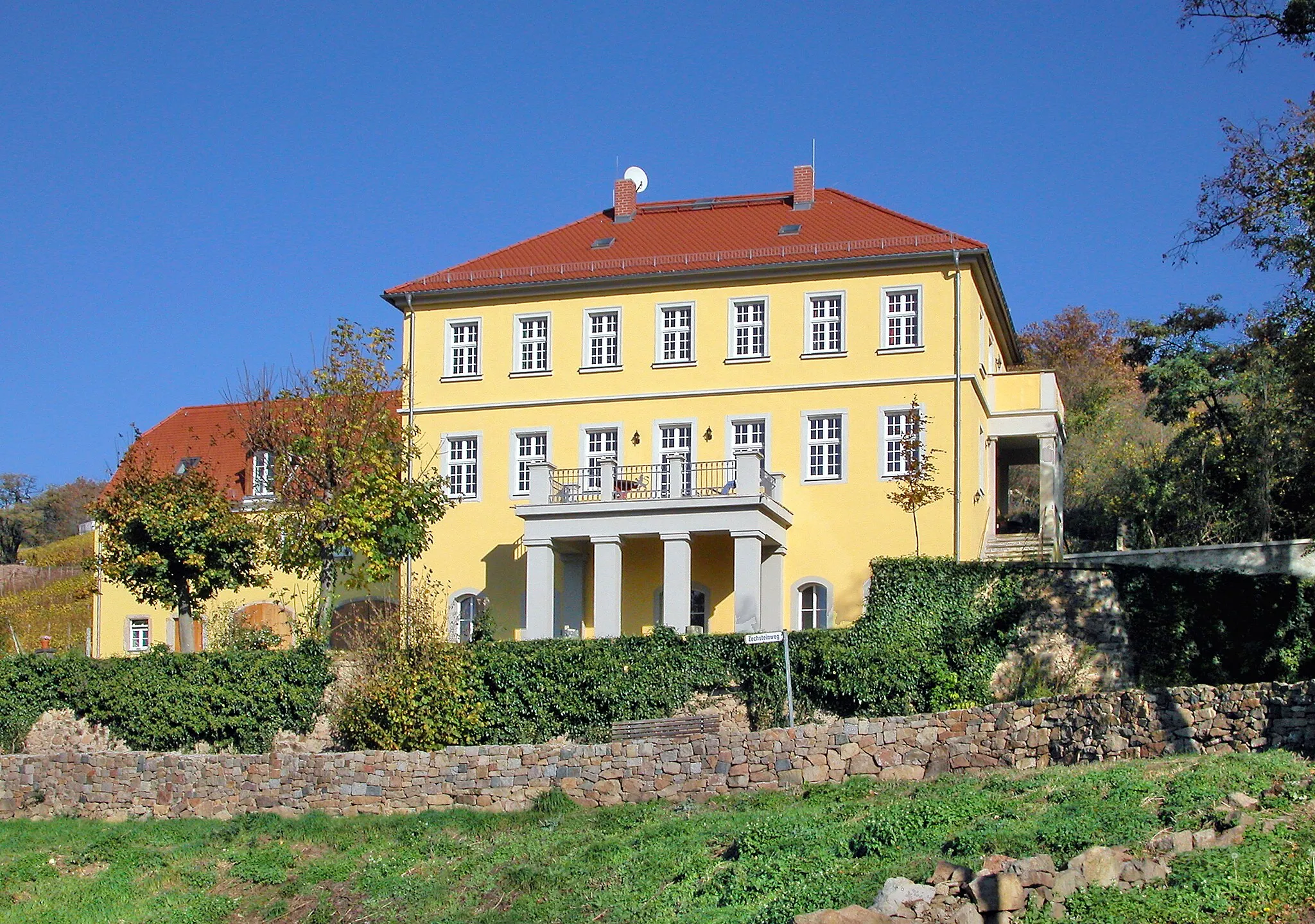 Photo showing: 24.10.2008  01445  Radebeul-Zitzschewig: Weingut Zechstein (GMP: 51.121719,13.610424), Barkengasse 17. Die urkundlich bezeugte Besitzerfolge beginnt 1699 mit dem kursächsischen Steuersekretär Johann Michael Findekeller, der auch Eigentümer der Bischofspresse war. Die Weinbergbesitzer waren seitdem überwiegend wohlhabende Bürger. Dies änderte sich mit dem Grafen Friedrich Magnus I. zu Solms-Wildenfels (1743-1801), der das Anwesen 1795 kaufte. Seine Witwe behielt den Zechstein bis 1825. Das heute zweistöckige Herrenhaus Zechstein entstand 1852 anstelle eines bereits 1706 erwähnten Vorgängergebäudes. Der oberhalb gelegene Weinberg Zechstein gehört zur Weinbau-Einzellage 'Radebeuler Johannisberg' innerhalb der Großlage 'Radebeul Lößnitz'. 1892 wurde die Weinwirtschaft eingestellt. 1918 kam das ehemalige Weingut an Ernst Böhm, der auf dem rund sechs Hektar großen Grundstück Landwirtschaft betrieb. 1946 wurde vom  Landesweingut Paulsberg wieder aufgerebt. Bis 1970 VEG Weinbau Radebeul. In den nächsten Jahren verfiel das Haus, aufgrund des schlechten Bauzustands wurden die Wohnungen bis 1988 leergezogen. 2003 erwarb Wilhelm Prinz von Hessen das Grundstück. Der Prinz gehört der Linie Hessen-Philippsthal-Barchfeld an, einer Nebenlinie des bis 1866 im Kurfürstentum Hessen regierenden Hauses Hessen-Kassel. Die Familie kam 2001 aus beruflichen Gründen nach Radebeul. Sie haben das Weingut in den letzten saniert. Das  Herrenhaus wird als Wohnhaus genutzt. Der Weinberg ist an Karl Friedrich Aust verpachtet. Er hat auch den Weinlehrpfad gestaltet, der unterhalb des Hauses Zechstein durch den Weinberg führt. Sicht von Süden.                                                                                                           [DSCN35011.TIF]20081024365DR.JPG(c)Blobelt