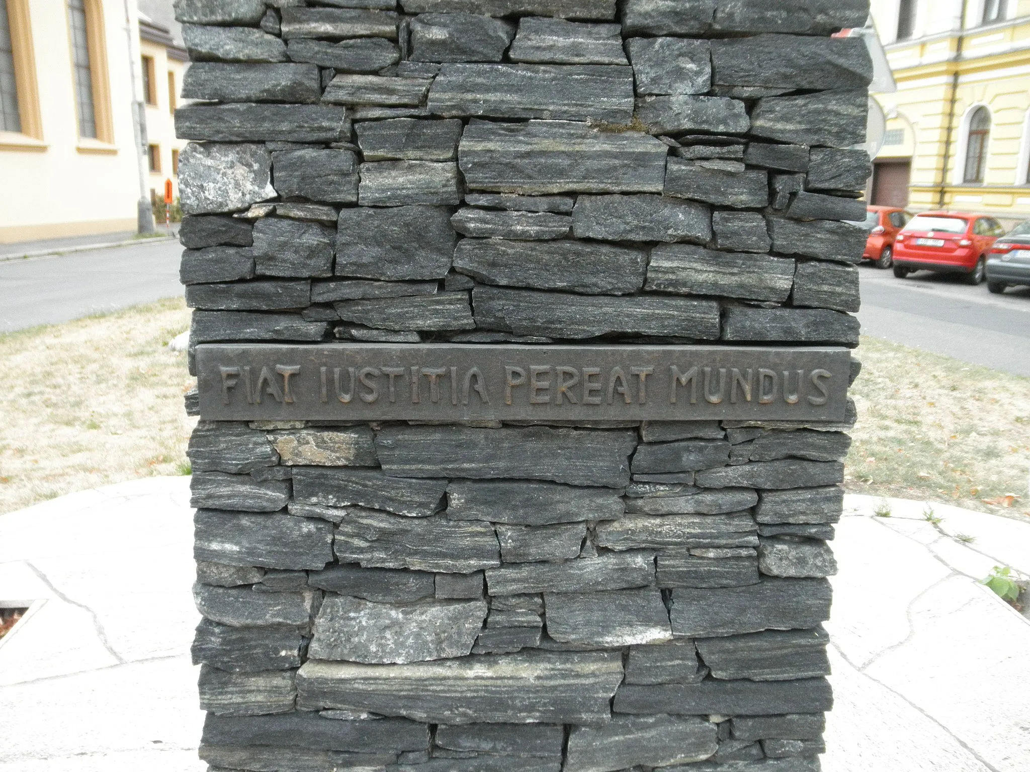 Photo showing: Inscription "Fiat iustitia pereat mundus". Detail of sculpture "The Scales of Justice" (Váhy spravedlnosti) in Politických vězňů street in Kolín. The sculptures was made by Ivan Erben in 2001.