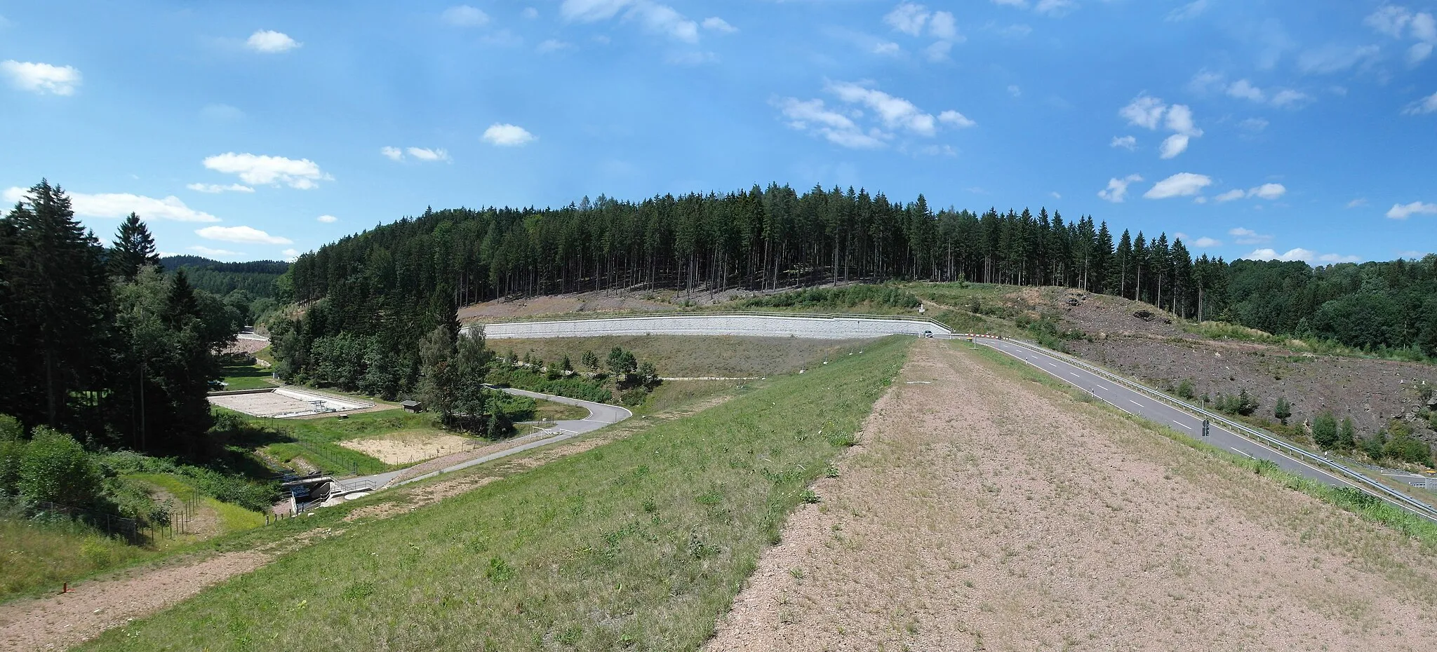 Photo showing: 26.07.2015     01768  Glashütte:  Neues Hochwasserrückhaltebecken Glashütte Prießnitztal (2009-2013). Links im Überflutungsbereich das bisherige Freibad. Steinschüttdamm (GMP: 50.844609,13.754744), Wasseroberfläche gefüllt: 11,1 ha, Speicherraum: 1,05 Mio m³, Baukosten 26 Millionen Euro.                         [SAM1195+1197+1199.JPG]20150726010MDR.JPG(c)Blobelt