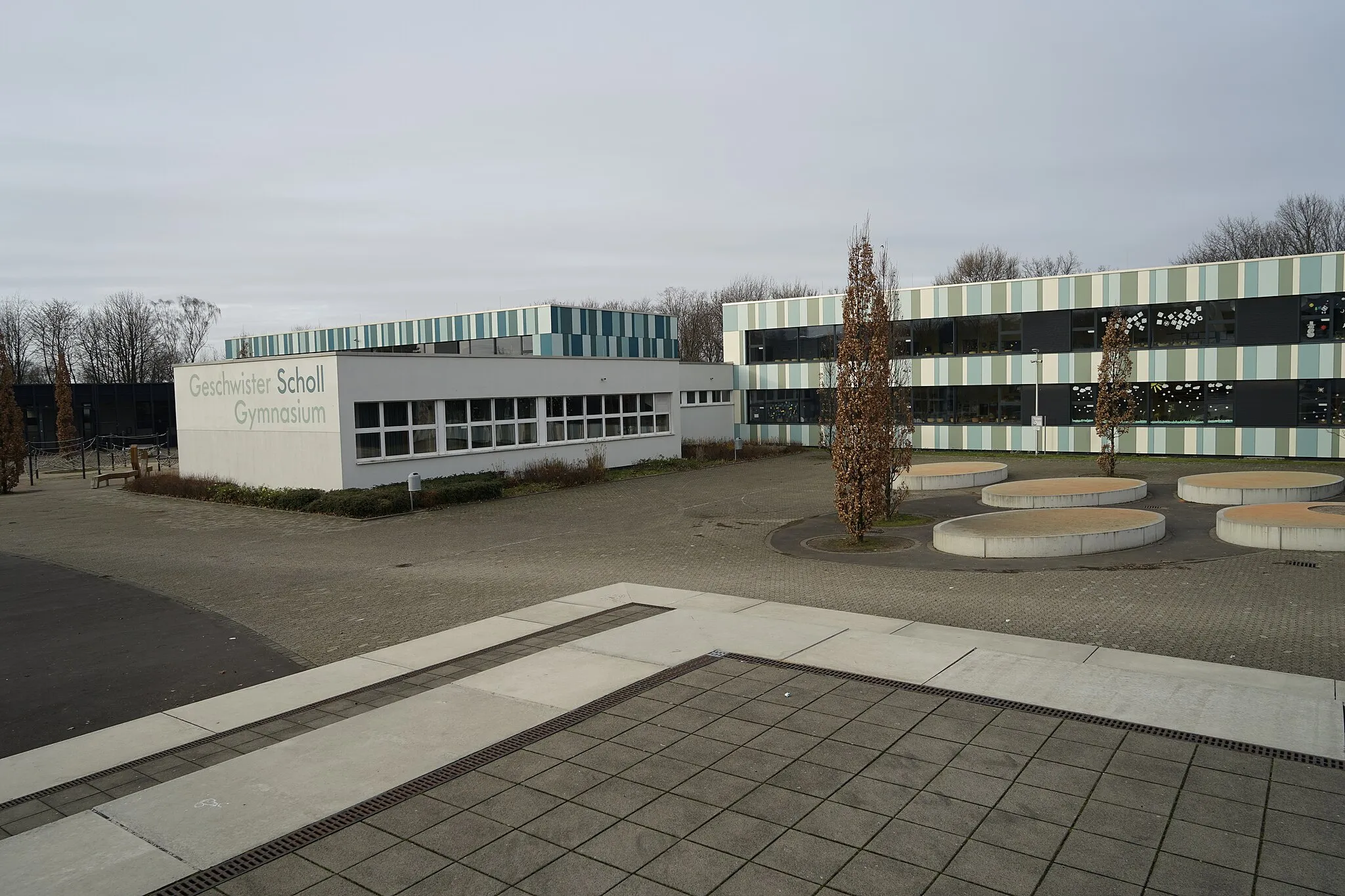Photo showing: Schulhof und weiterer Trakt des Gymnasiums. Hinter dem Eingangsbereich gelegen.