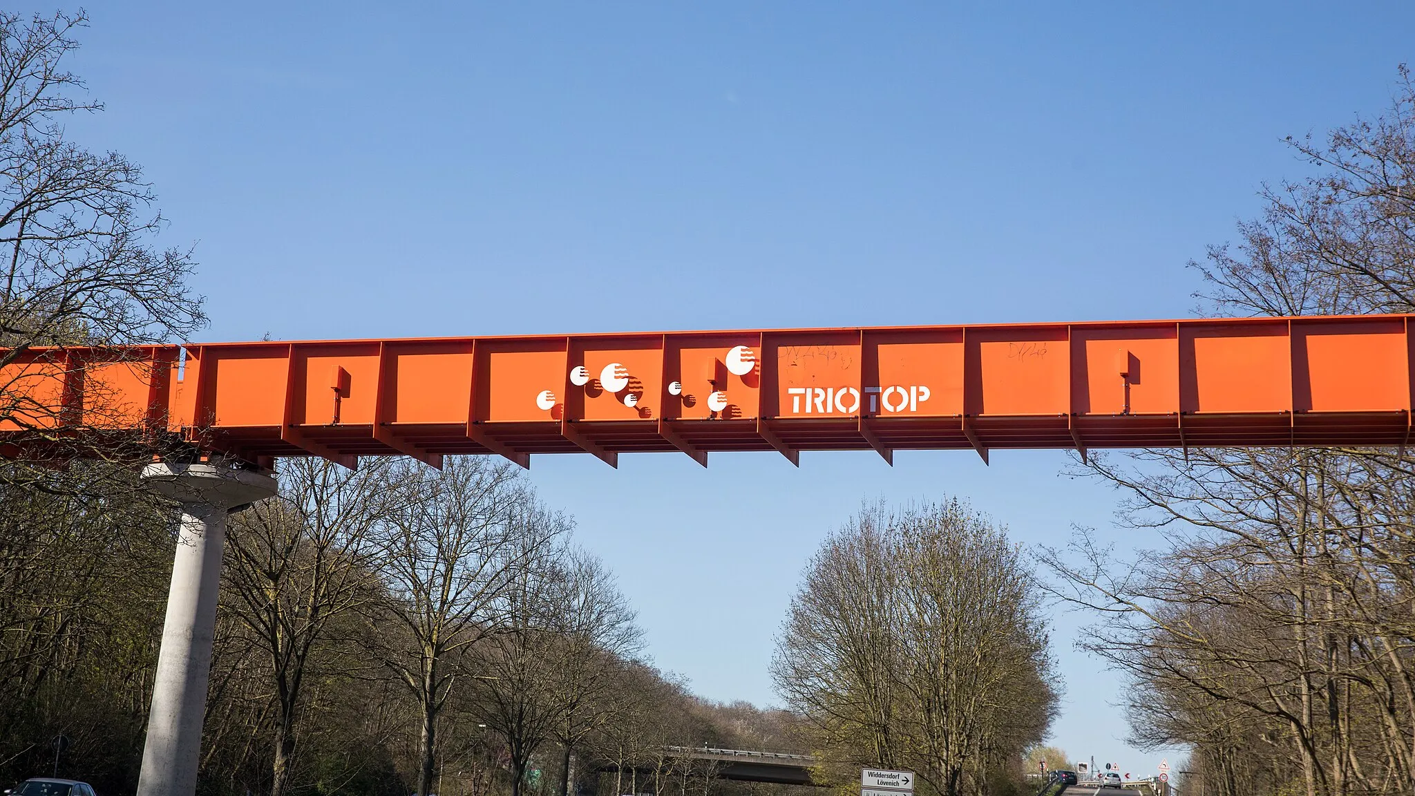 Photo showing: Belvederebrücke über Militärringstraße nordwärts in Höhe Gregor-Mendel-Ring, Köln. Der Schriftzup „Triotop“ verweist auf den rechts liegenden Gewerbe- und Landschaftspark „Triotop“