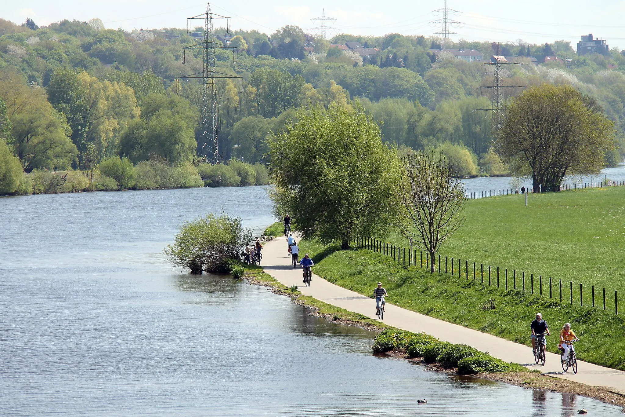 Photo showing: Blick von der Fußgängerbrücke über die Ruhr auf den Ruhrtalradweg mit Radfahrern und Bochum-Dahlhausen; am Ufer 220-kV-Freileitung (Bl. 2314) in Bochum