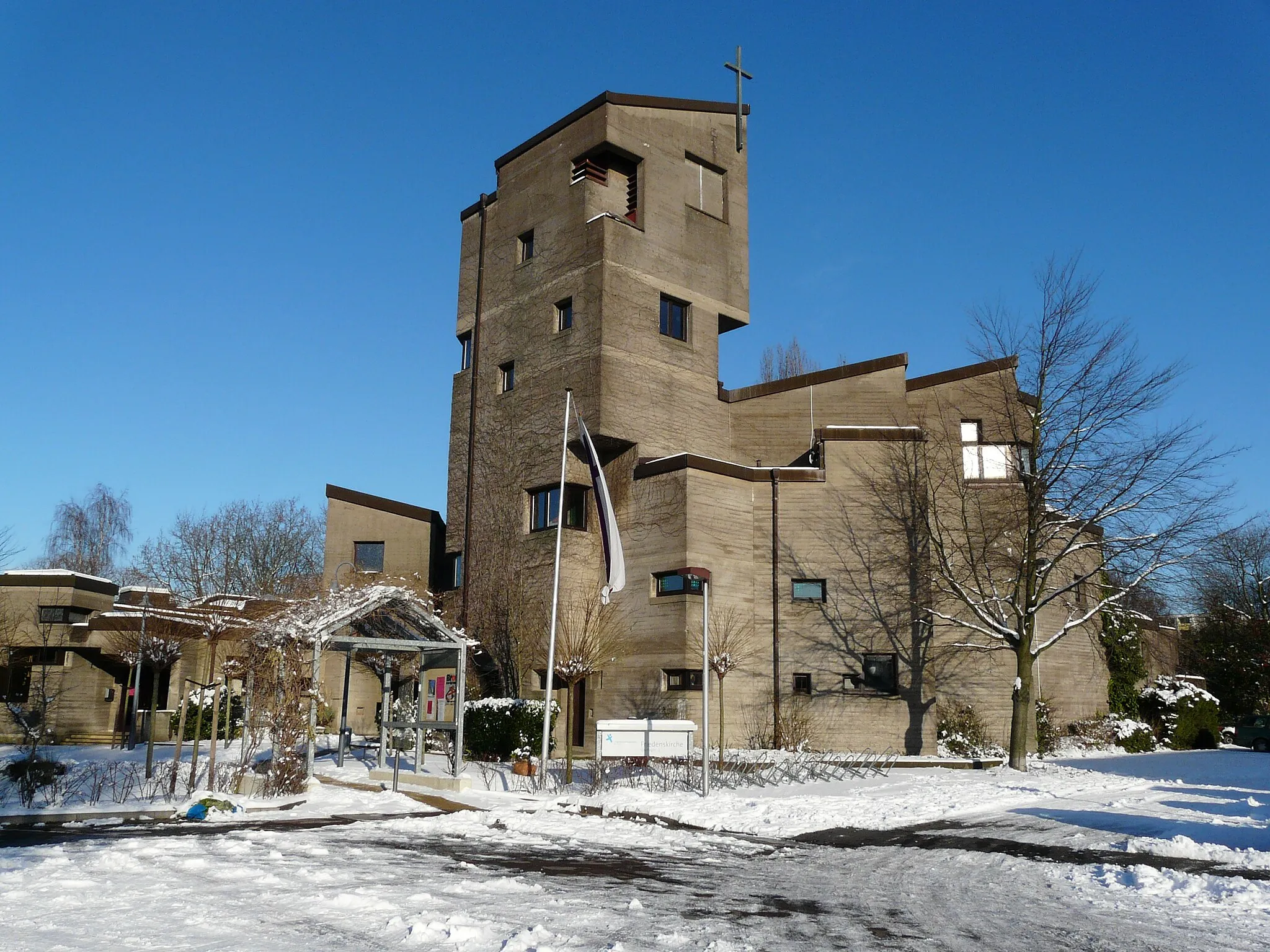 Photo showing: Die Abbildung stellt die Friedenskirche Baumberg in der Ansicht von Süden dar. Durch die fehlende Belaubung der Kletterpflanzen ist die äußere Struktur zu dieser Jahreszeit besser sichtbar.
