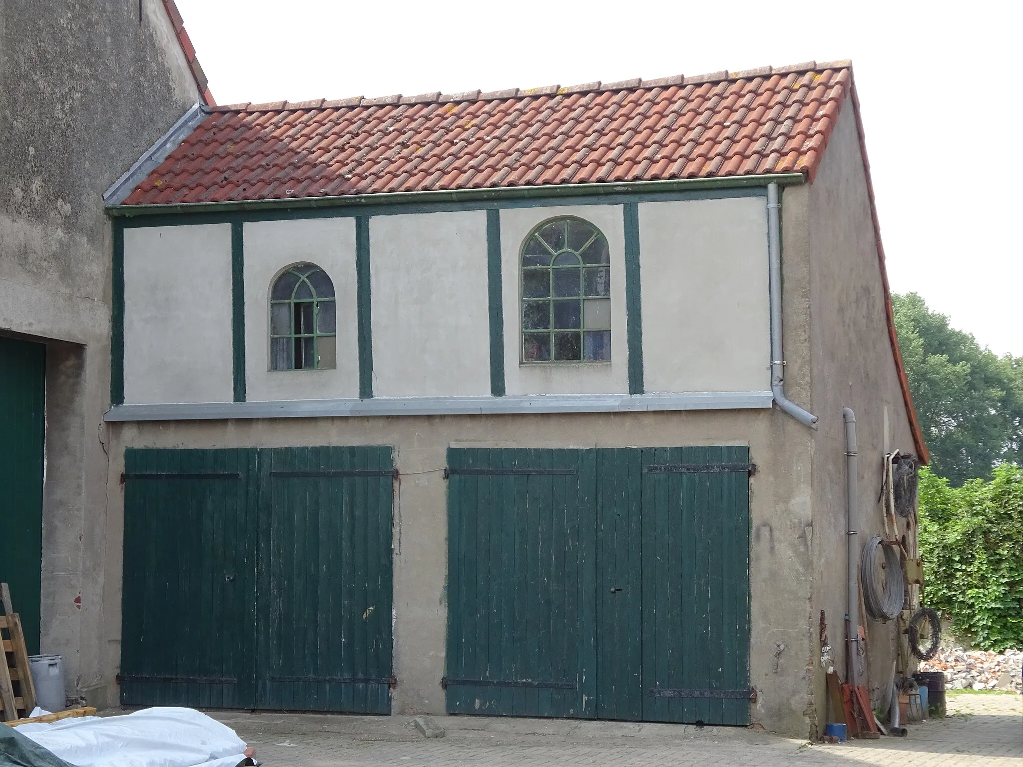 Photo showing: Rees-Grietherort 3, aangebouwde garage met twee groene deuren en zolder met boogramen