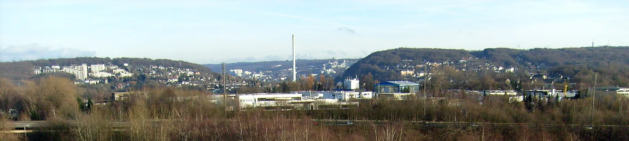 Photo showing: Die engste Stelle des Tales in der Großstadt Wuppertal befindet sich zwischen dem Nützenberg (links) und dem Kiesberg (rechts). An dieser Talenge steht das Heizkraftwerk Elberfeld an der Kabelstraße. Der hohe Schornstein überragt beide Berge.
