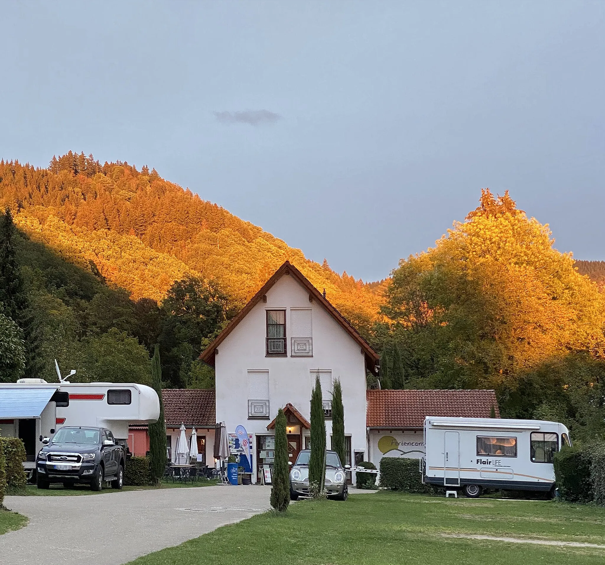 Photo showing: Evening mood in the Black Forest. Partial extreme red discoloration of the mountain landscape, caused by gaps in the cloud front in the west. Seen in Oberweiler (Badenweiler).