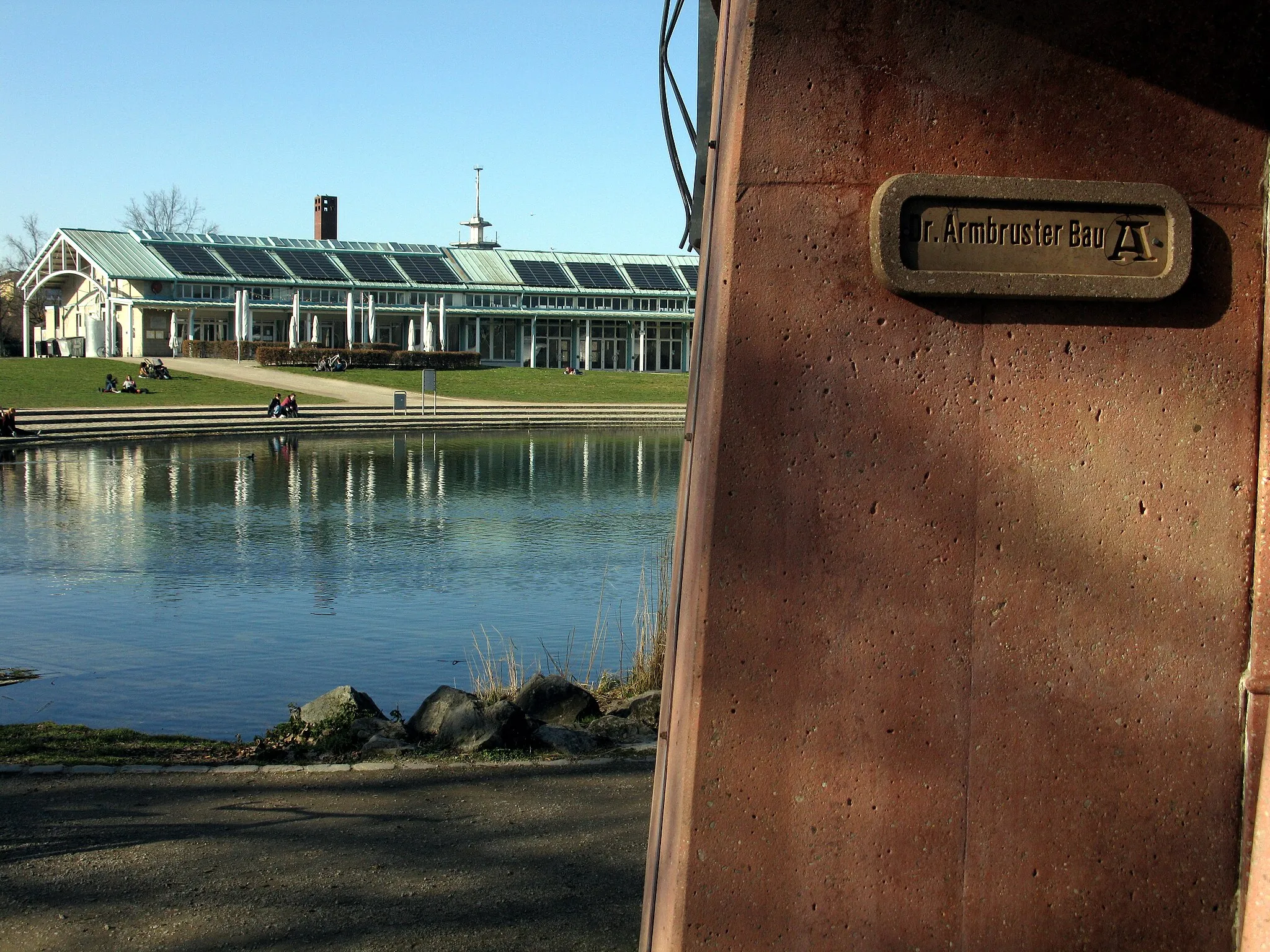 Photo showing: Tempelchen im Freiburger Seepark mit Schild Dr. Armbruster Bau, im Hintergrund das Bürgerhaus