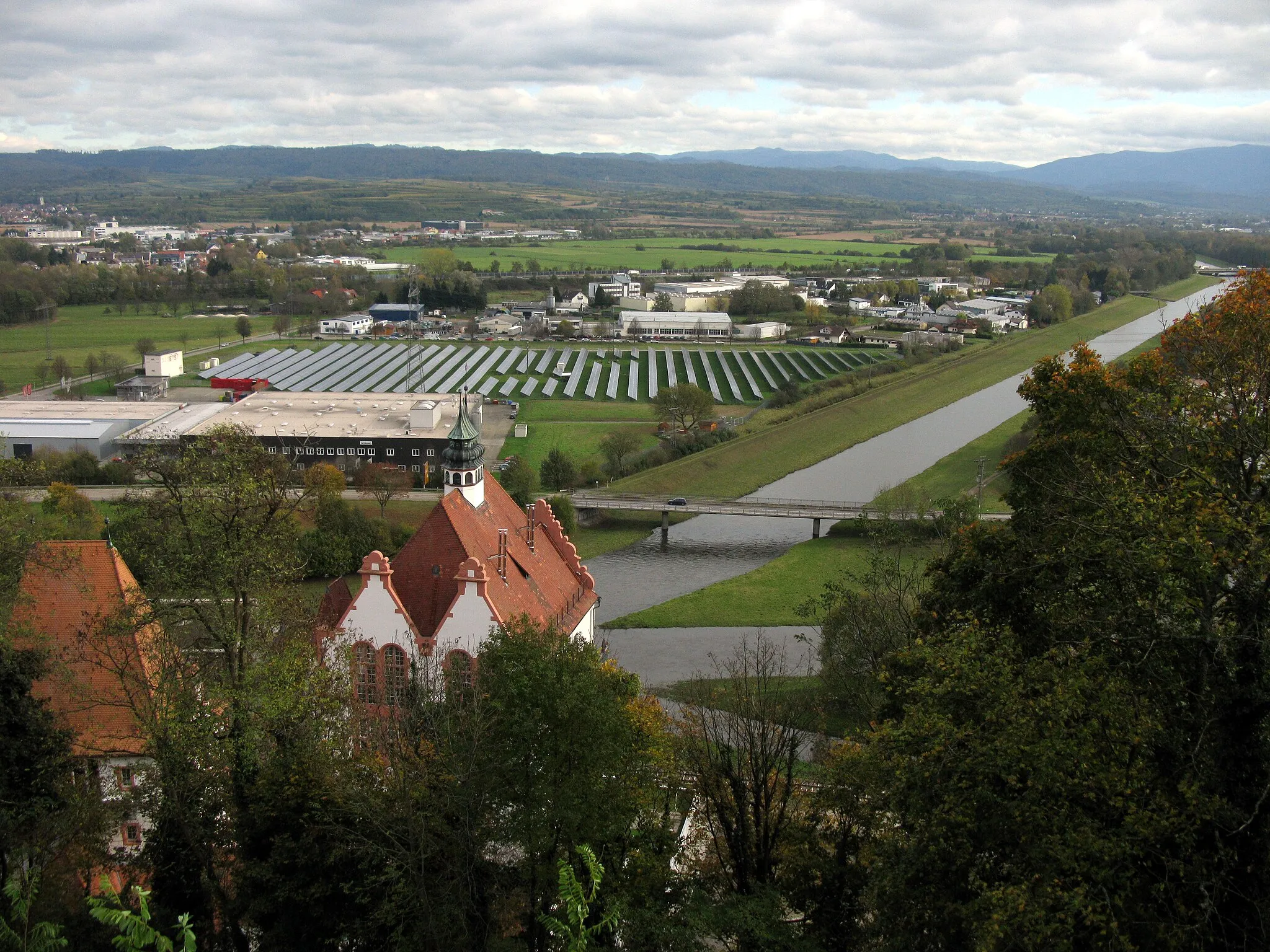 Photo showing: Blick von der Michaelskapelle in Riegel auf die kanalisierte Elz, im Vordergrund das Sudhaus der ehemaligen Brauerei, rechts davon Alte (vorne) und neue Dreisam