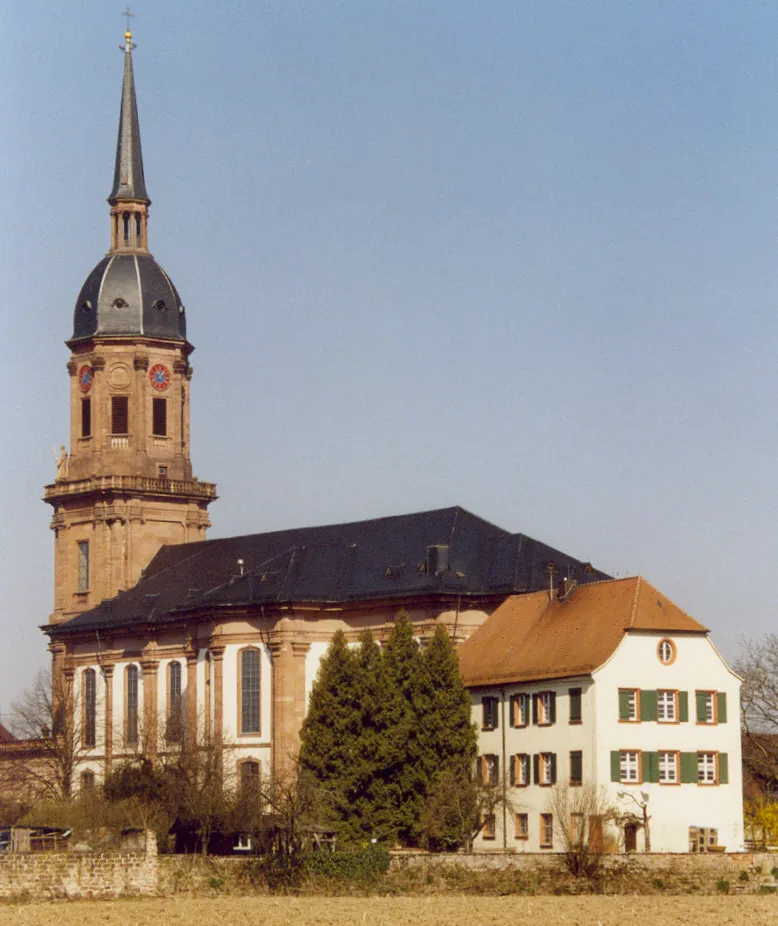 Photo showing: Schutterns ehemalige Klosterkirche, jetzt Pfarrkirche Mariae Himmelfahrt. Ein vortreffliches Werk des Barockstiles (18. Jahrhundert). Ihm zur Seite ein Ãberrest des klÃ¶sterlichen Konventbaus (als Pfarrhaus genutzt).