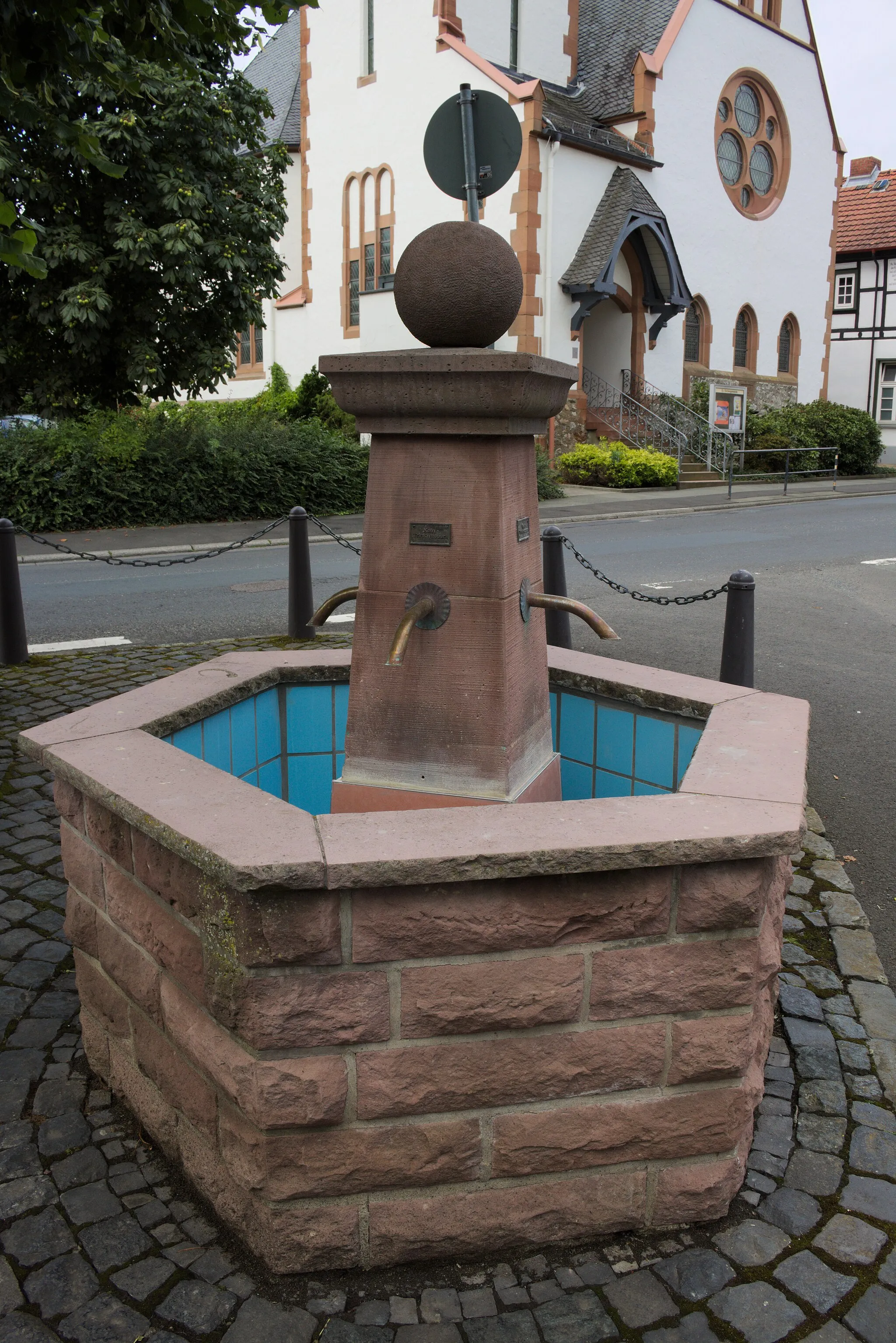 Photo showing: Der Brunnen im Dorfkern in Fellingshausen, direkt vor der Kirche, nachdem Fliesen im Brunnen angebracht wurden. (Stand: 18.08.2015)