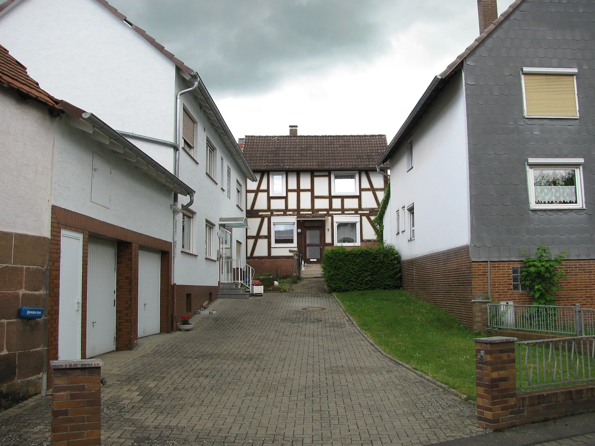 Photo showing: Blick in den Hof zwischen den Häusern Ohmtalstraße 3 links, Nr. 5 hinten und die Rückseite des Hauses Nr. 7 rechts, die Stolpersteine liegen vor der Grundstücksmauer vorne rechts
