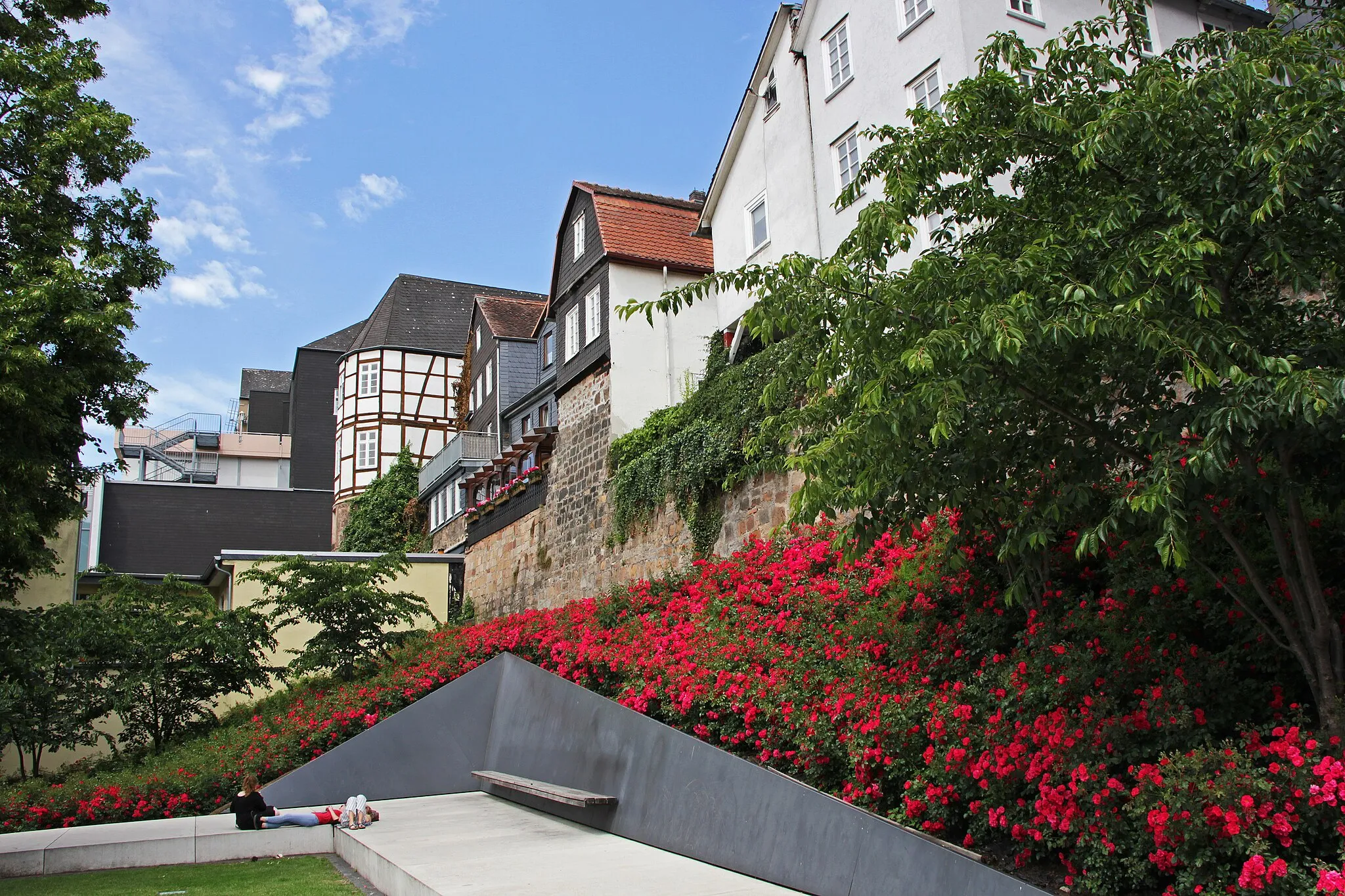 Photo showing: “Garten des Gedenkens” (Teilansicht) an der Stelle der ehemaligen Synagoge (1897-1938) in der Universitätsstraße in Marburg vor der südlichen mittelalterlichen Stadtmauer mit dem Hundsturm. Ansicht von Osten.