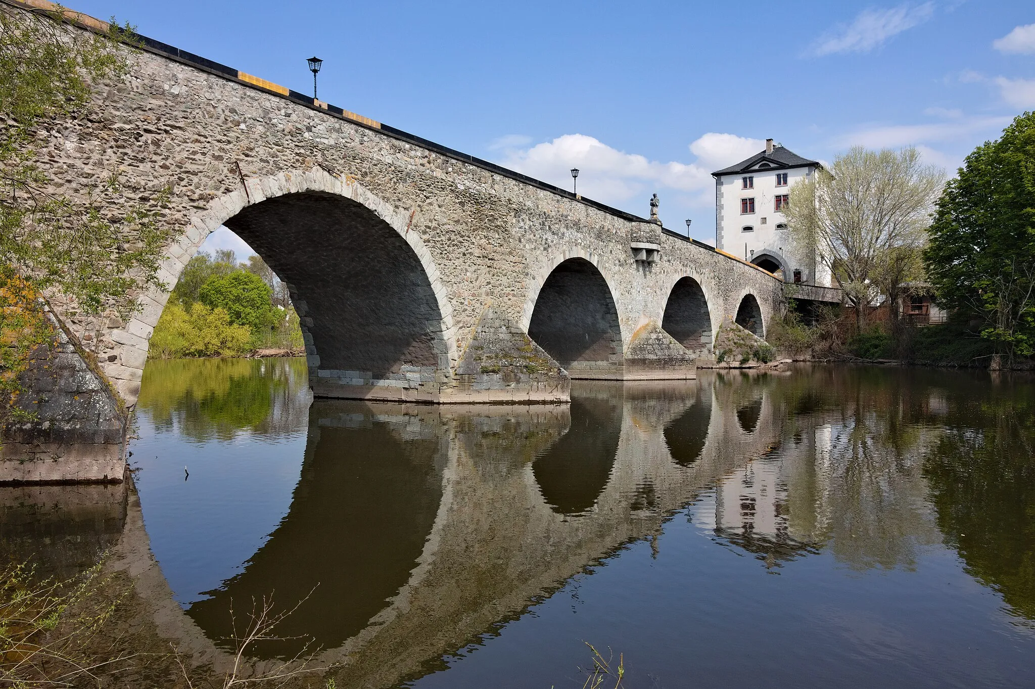 Photo showing: The old bridge over the Lahn river with a bridge tower at Limburg an der Lahn, Germany. The bridge was originally built during the first half of the 14th century. It was demolished during the war in 1945 and restored as well as broadened until 1948. View from the southern river bank onto the eastern side of the bridge.