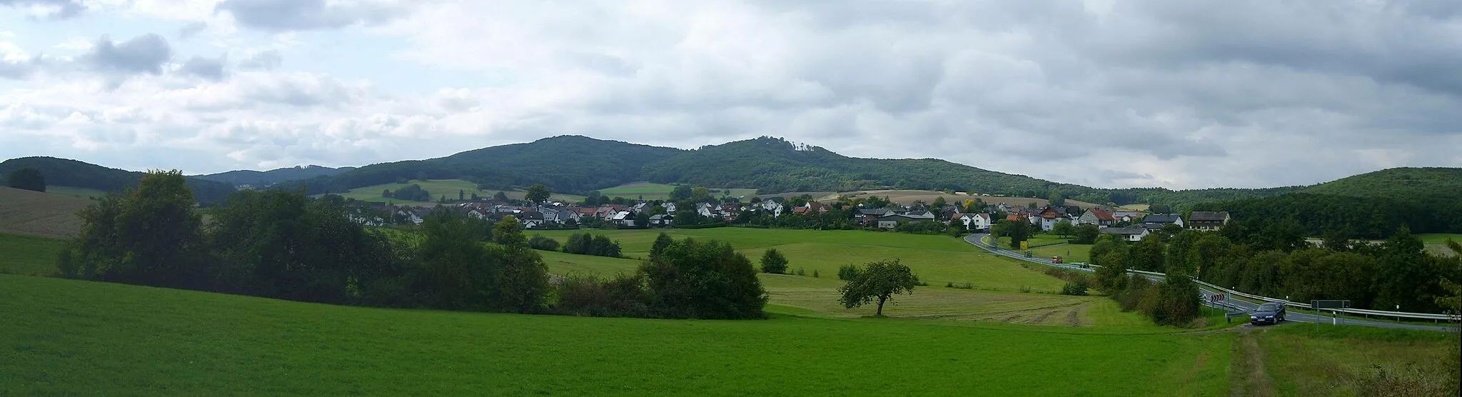 Photo showing: Daubhaus (552 m, links der Mitte) und Allberg (528 m) am äußersten Ostrand der Bottenhorner Hochflächen. Im Vordergrund der Gladenbacher Ortsteil Runzhausen