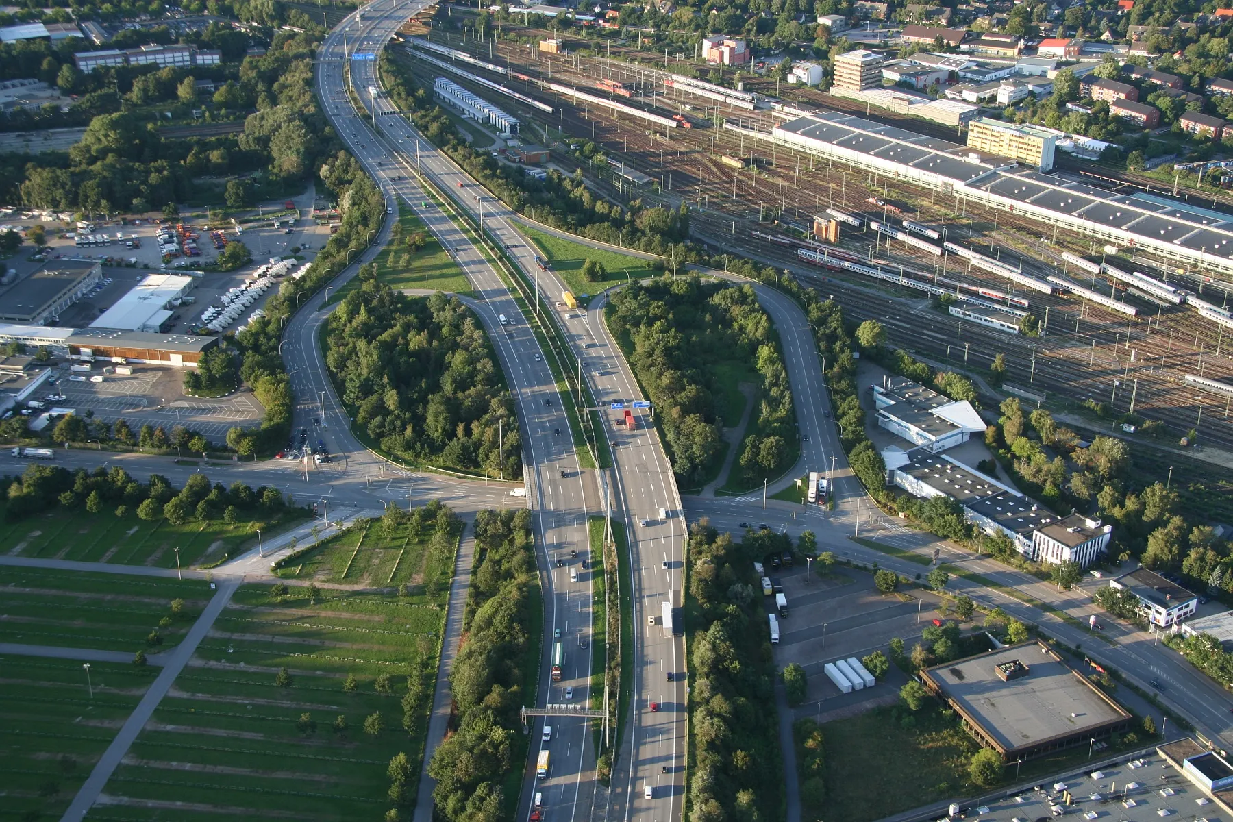 Photo showing: Ausfahrt "Volkspark" der A7, dahinter das Bahnbetriebswerk Langenfelde. Dazwischen verläuft die Grenze zwischen Stellingen (Bahn) und Bahrenfeld (Autobahn).