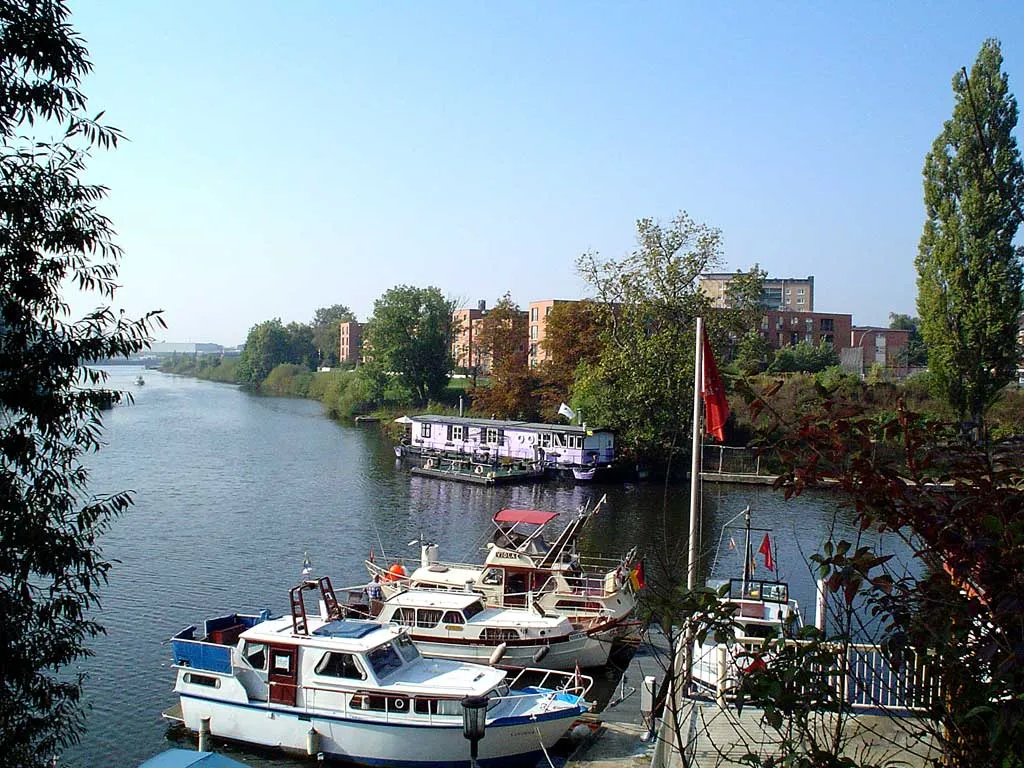 Photo showing: Blick von der Braunen Brücke in Hamburg-Hamm-Süd auf einen Motorboothafen, ein Hausboot (lila) sowie die neu gebauten Wohnungen der "Baugenossenschaft freier Gewerkschafter".