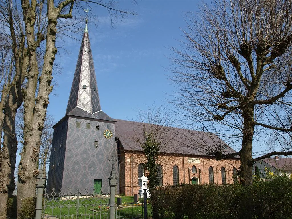 Photo showing: Kollmar  (Schleswig-Holstein, Germany), church (built in 15th century) , photo 2009 - The Church is a single-nave brick building with a three-sided east end. It was built on the old dike line in the middle of the 15th century. The interior was renewed in the 17th century, and the exterior was redesigned in 1858.
- The wooden west tower probably dates from the 17th century. It is completely covered with slate. Different colored slates are arranged in a diamond pattern.