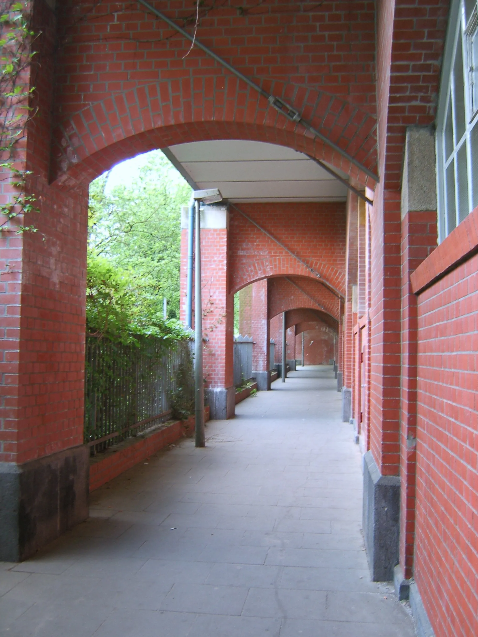 Photo showing: Fußweg an der U-Bahnstation Uhlandstraße in Hohenfelde. Der Bahnsteig liegt oberhalb des Weges.